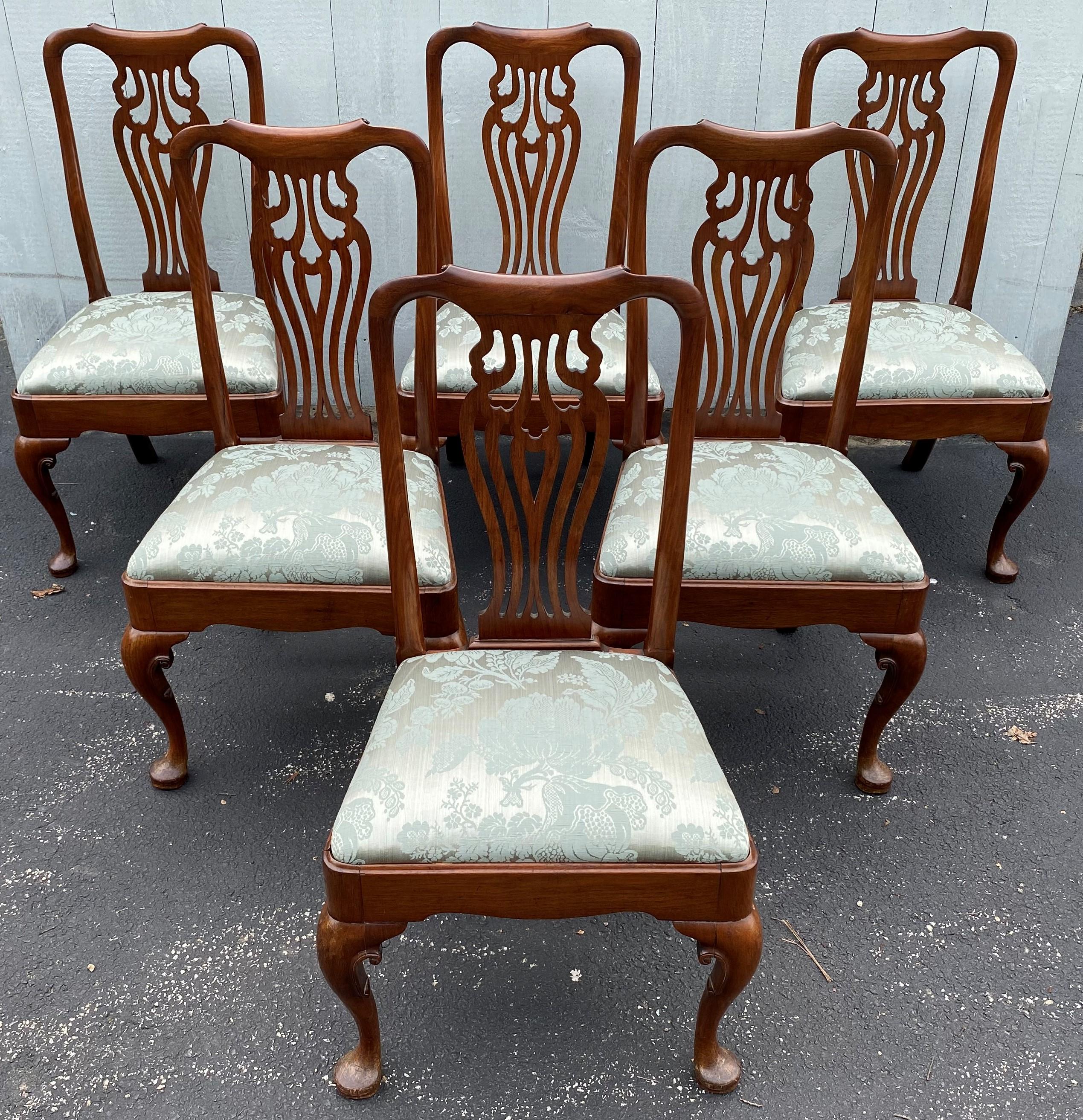 An exceptional set of six Queen Anne walnut dining or side chairs with hand carved reticulated splats and front cabriole legs terminating with pad feet. The slip seats have been recently refreshed with a pale green Damask upholstery. This set is