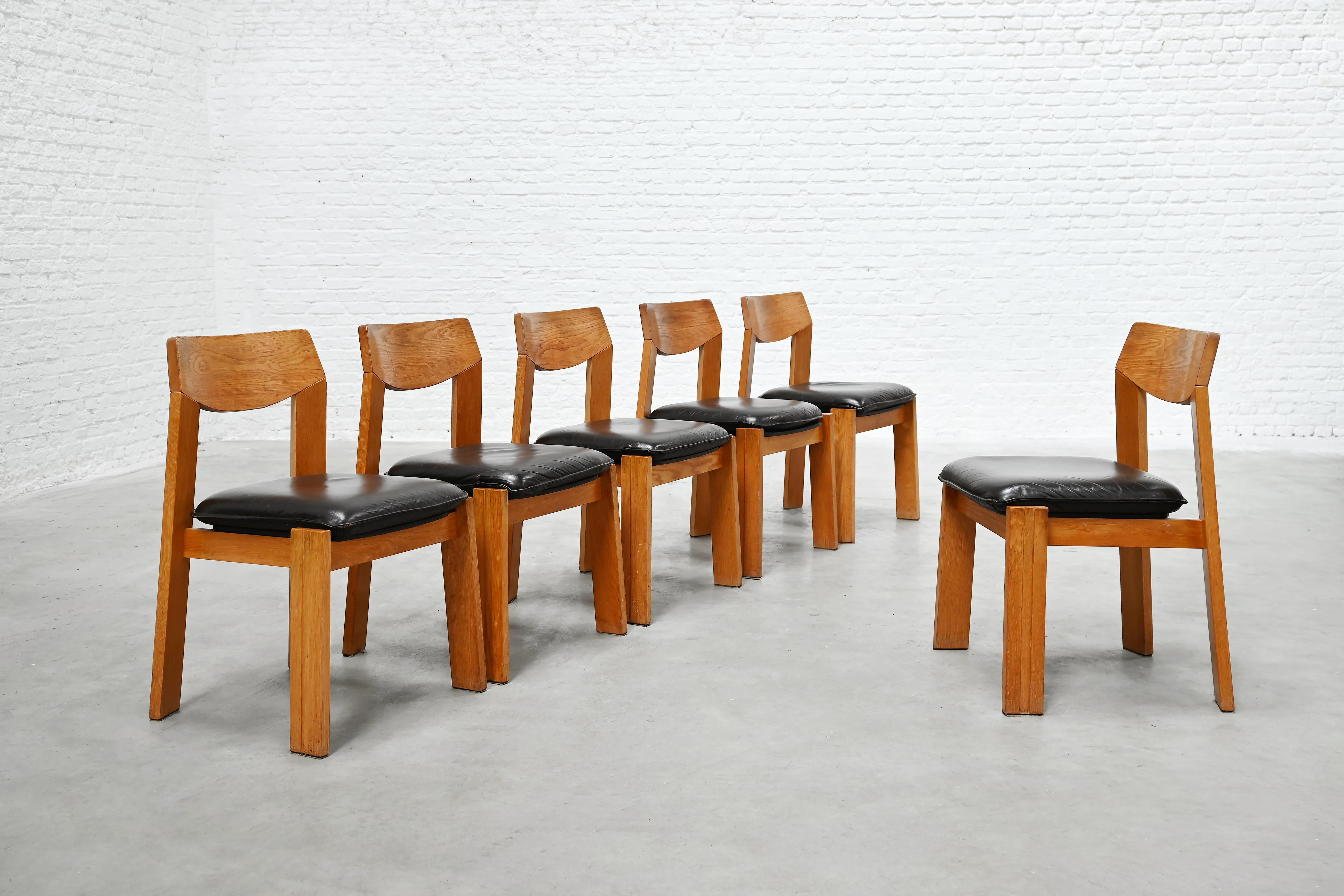 Ein raffiniertes Set aus sechs brutalistischen Eichenstühlen aus den 1970er Jahren mit warmen, natürlichen Holztönen und einer markanten architektonischen Silhouette. Das Design kombiniert sanft geschwungene Rückenlehnen mit breiten, strukturierten