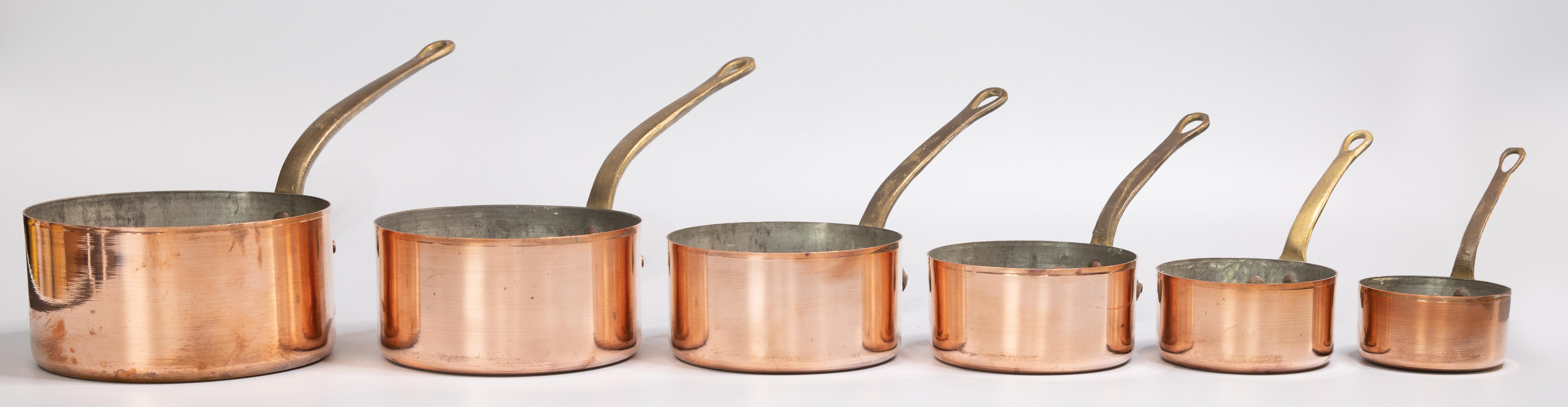 A gorgeous set of six antique 19th century French copper sauce pans. The lovely long handles are solid brass and the pots have a beautiful patina. They are perfect for French Country decor, beautiful hanging on a pot rack or wall.

Saucepans