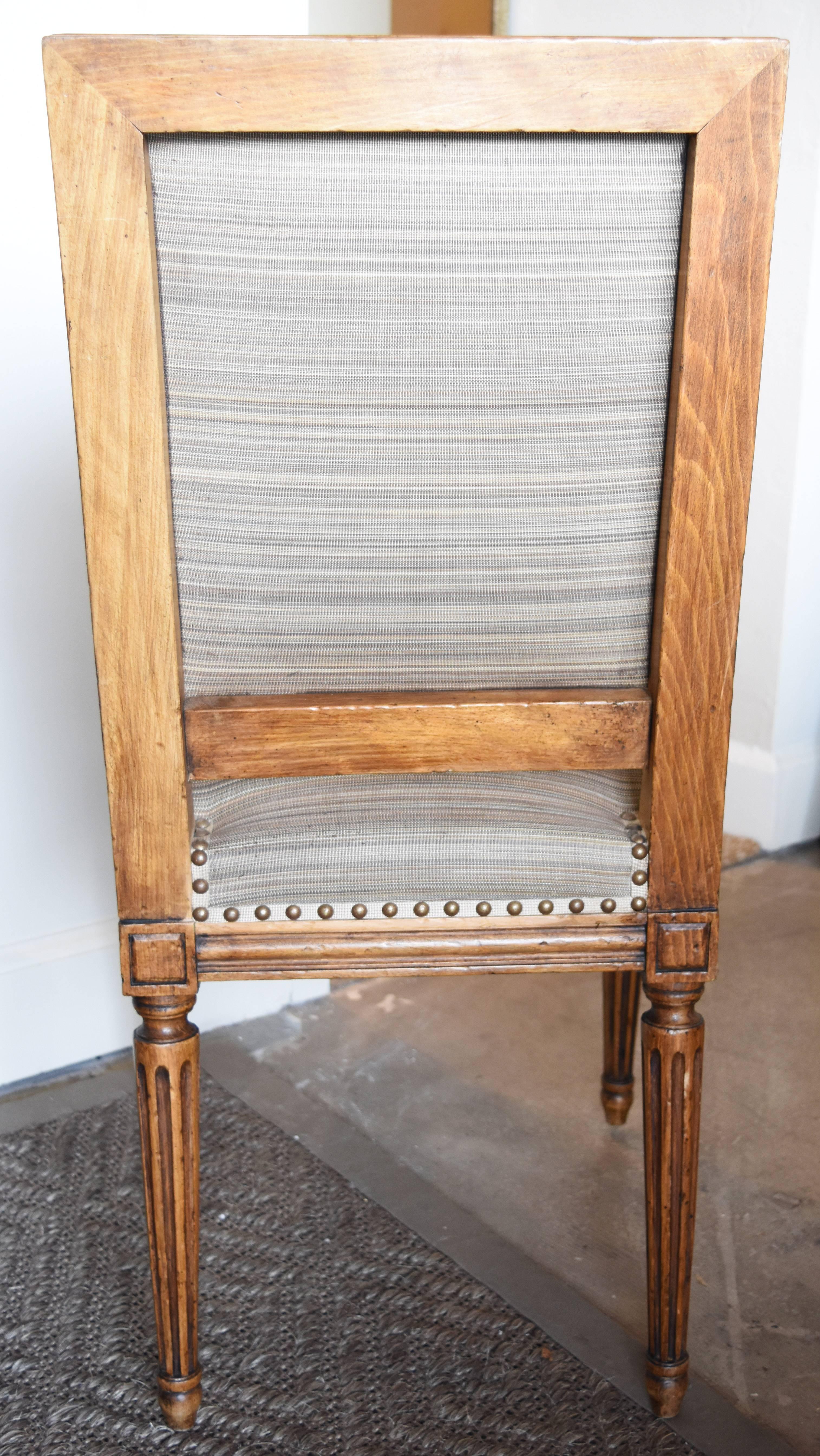 This set of six French walnut Dining Chairs is upholstered in a grey / taupe horizontal striped fabric and finished with nail heads. The fabric is not new but appears to be in good shape. The legs are fluted and sturdy with no need for tightening.