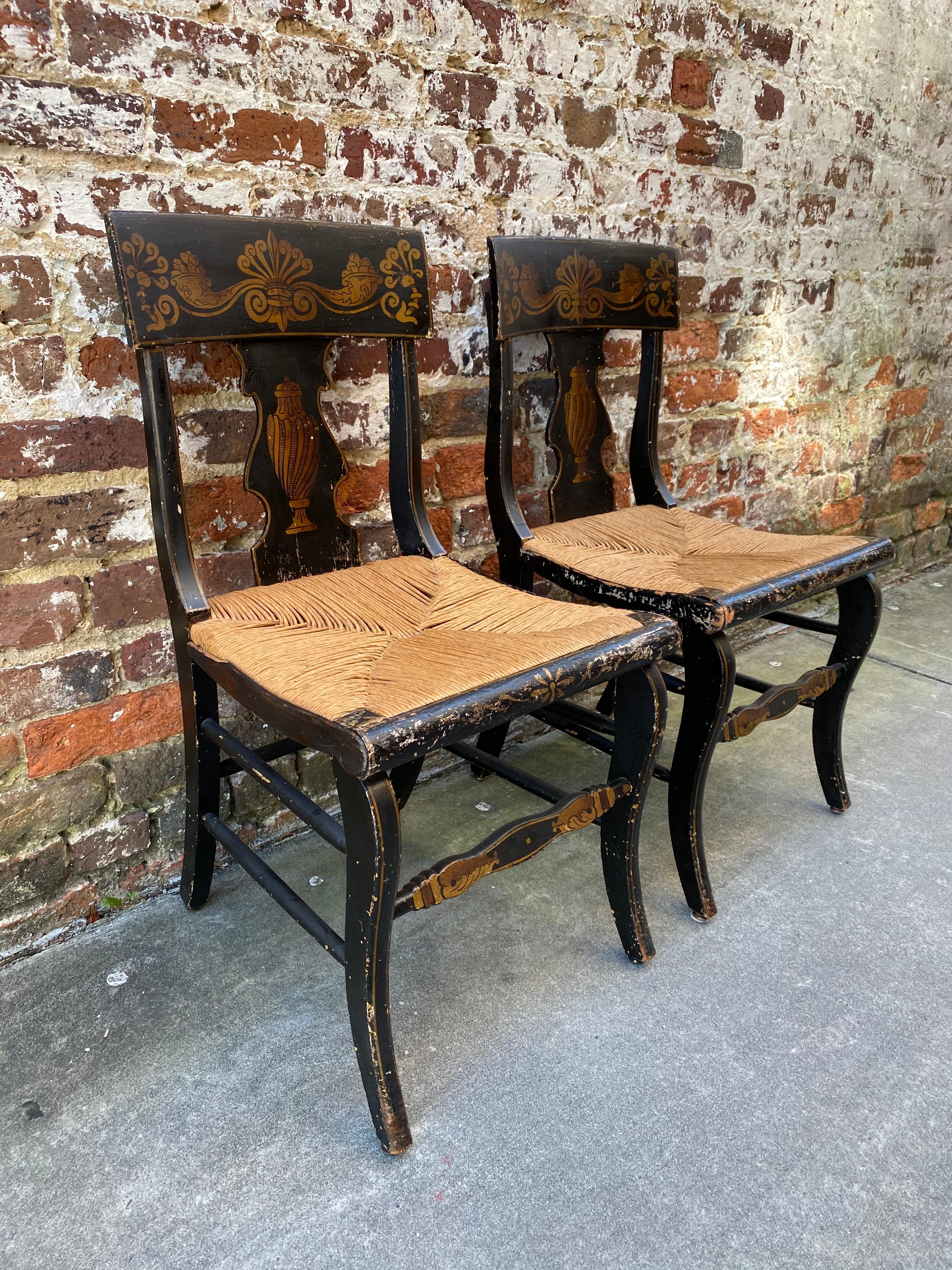 set of 6 painted saber leg chairs with rush bottom seats. 19th century black painted with gold stenciled paint.