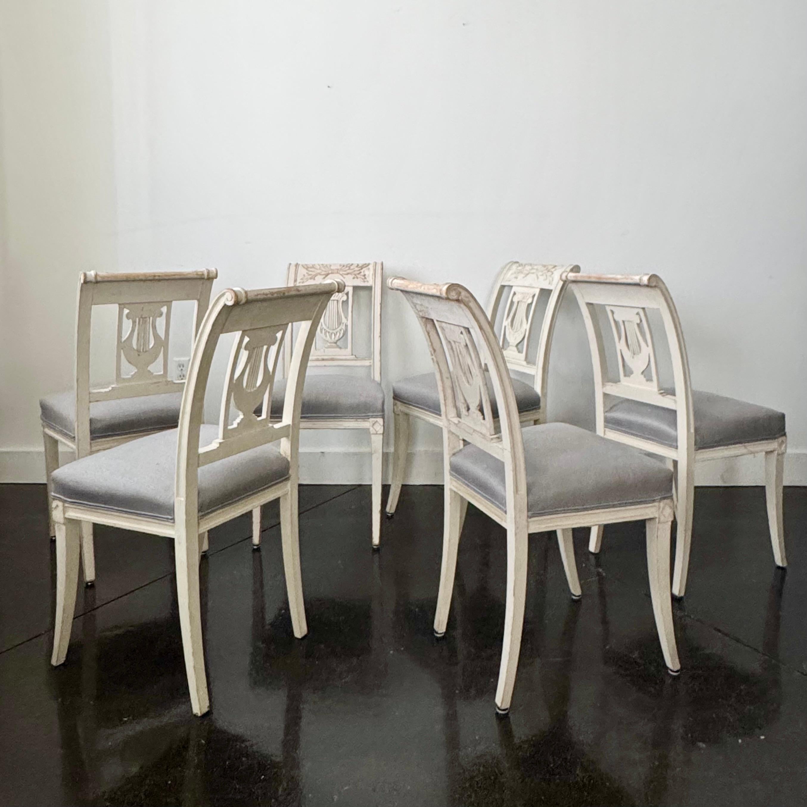 Affascinante set di sei sedie da pranzo svedesi con schienali riccamente intagliati con motivi a lira e a foglie. Sedile con imbottitura recente in lino.

