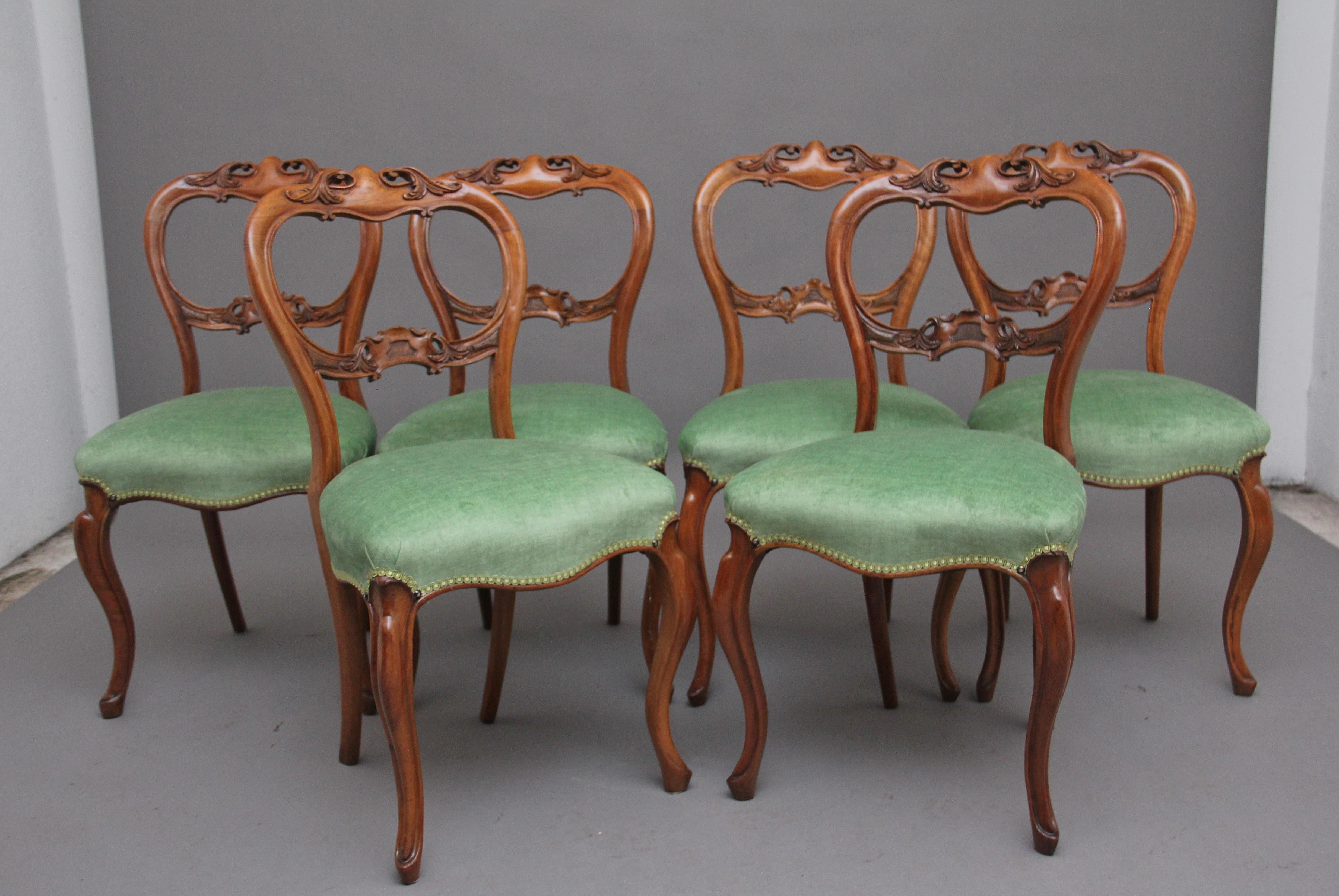 A fine quality set of six 19th century carved walnut dining chairs having a decorative carved top rail and shaped centre splat which is also beautifully carved and pierced, newly reupholstered stuffover seat in a green fabric supported on elegant