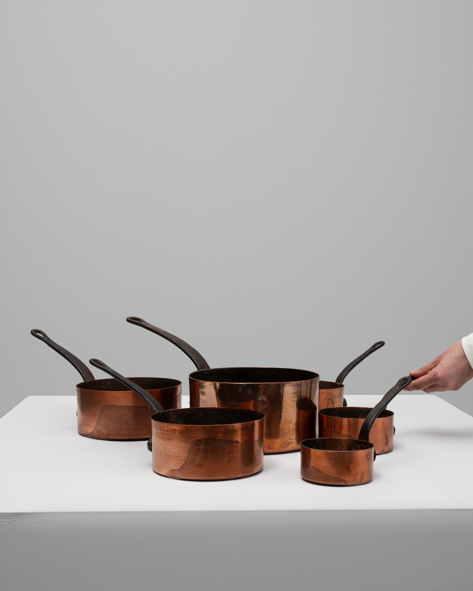 Dieses Set aus sechs französischen Messingtöpfen des 20. Jahrhunderts zeigt die zeitlose Handwerkskunst und Eleganz des traditionellen französischen Kochgeschirrs. Jede Kanne hat einen warmen, polierten Messingkorpus und robuste schmiedeeiserne