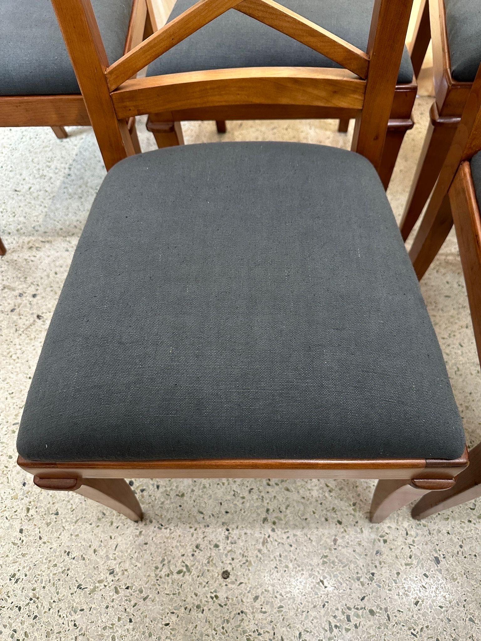 In the manner of Jacques Adnet, these six French oak dining chairs with lattice back and tapering legs have been reupholstered in a thick charcoal gray linen fabric.  They are sturdy and restored beautifully.