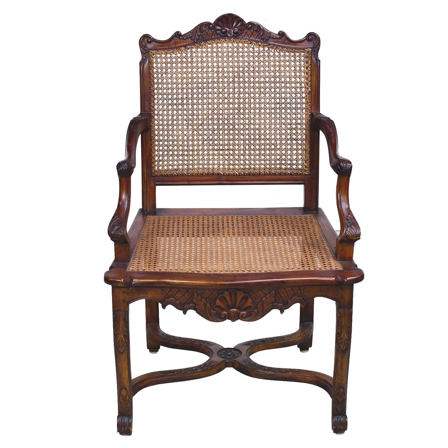 A beautiful and well-crafted set of six (6) dining chairs in mahogany comprising of two (2) armchairs and four (4) side chairs in the French Louis XIV style with caned back and seat. Rocaille & acanthus carvings embellish the crest rail, apron,