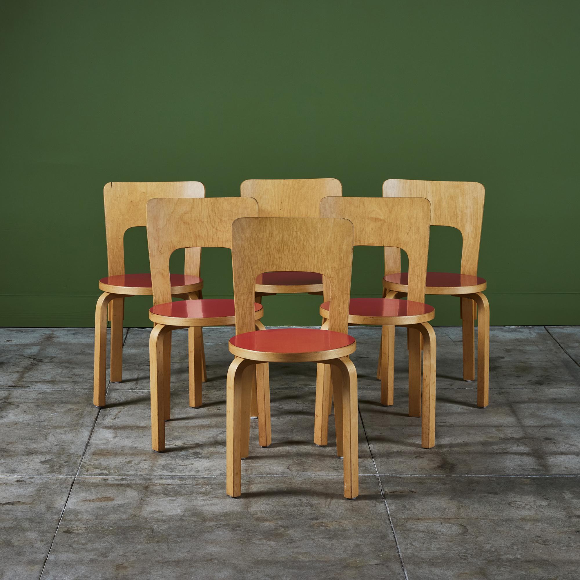 Der von Alvar Aalto entworfene und in den 1950er Jahren hergestellte Esszimmerstuhl Model 66 von Artek verfügt über honigfarbene Birkenbeine und eine hohe, gebogene Rückenlehne aus Sperrholz. Der Sitz besteht aus rundem Birkenholz mit rotem Laminat