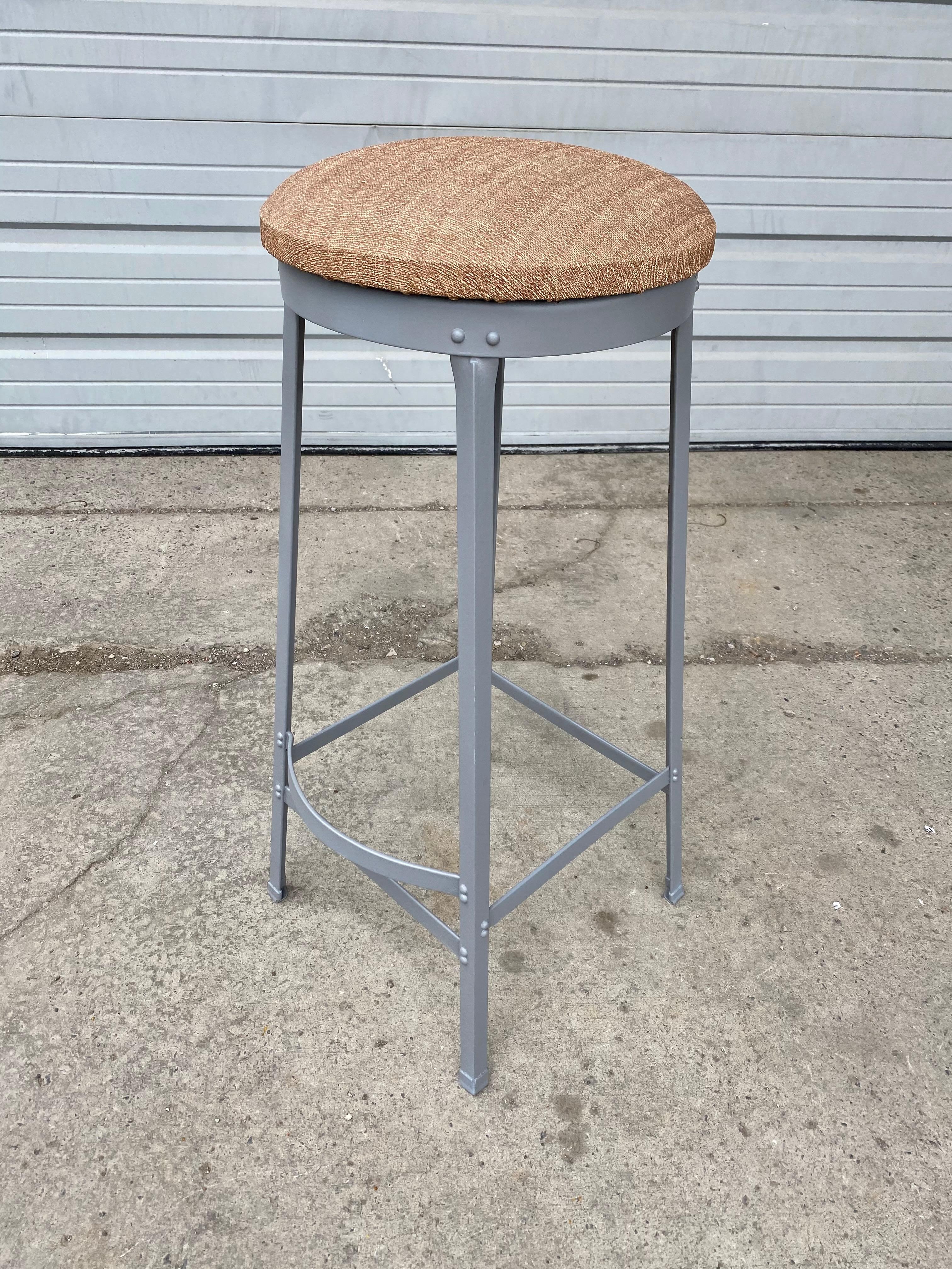 A handsome set of 6 vintage American Industrial iron bar stools with foot rests, bent-stock feet, attributed to Toledo metal furniture, metal recently restored, painted, appears to be original upholstered seats. Hand delivery avail to New York City