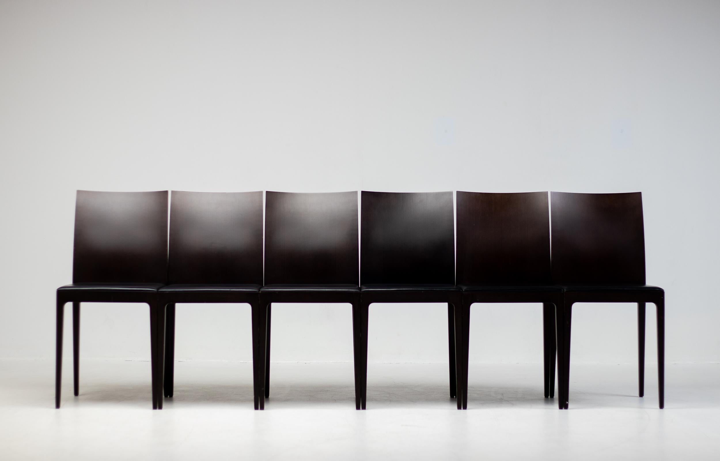 A set of six Anna R dining chairs designed by Ludovica and Roberto Palomba for Crassevig, Italy. 
These chairs feature a dark brown solid wood frame with double-paneled back and a seat panel upholstered in black leather. Marked Crassevig made in