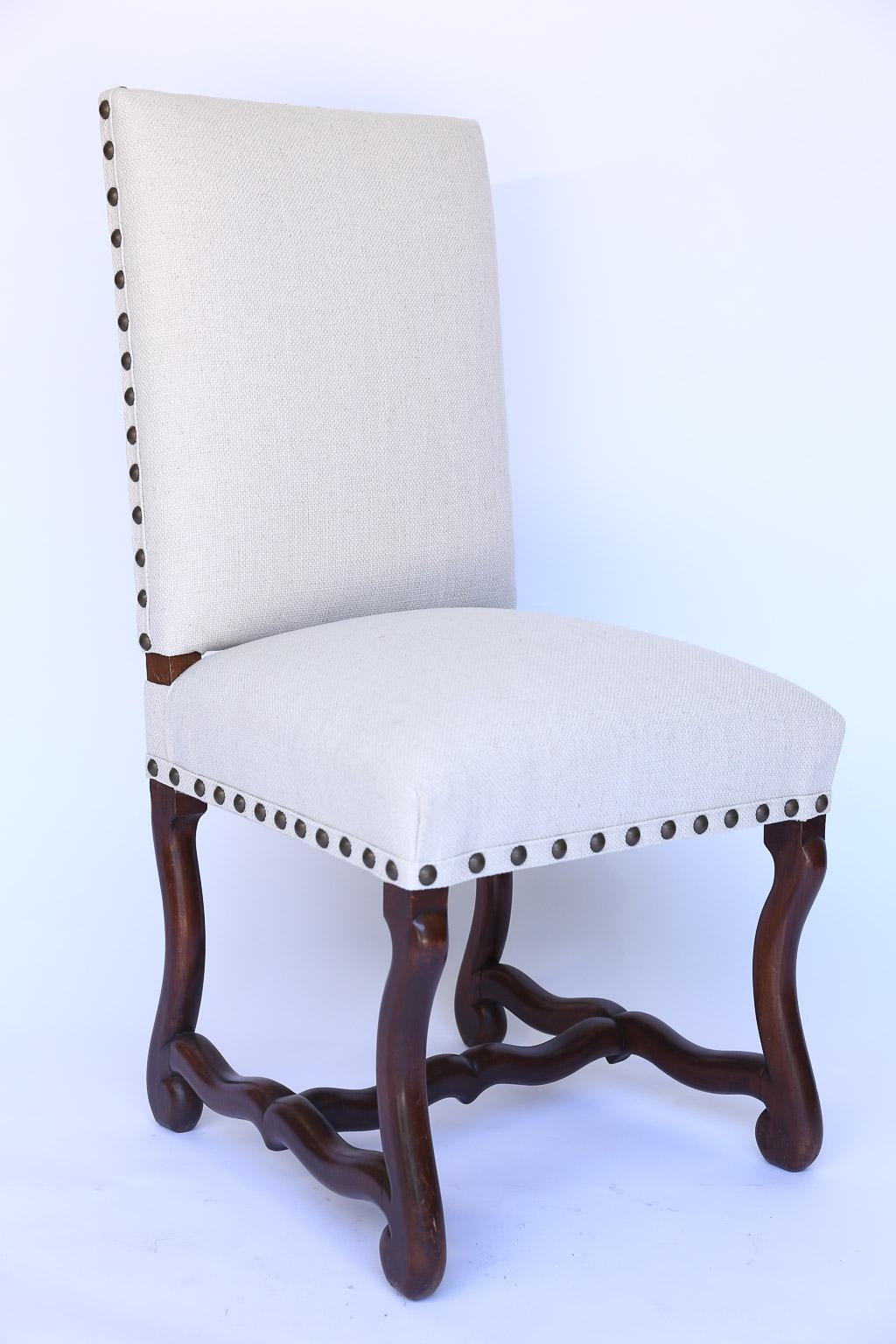 This is a set of six newly upholstered dining side chairs from France. With new padding and fill, the white linen blend fabric is enhanced by brass nail heads.