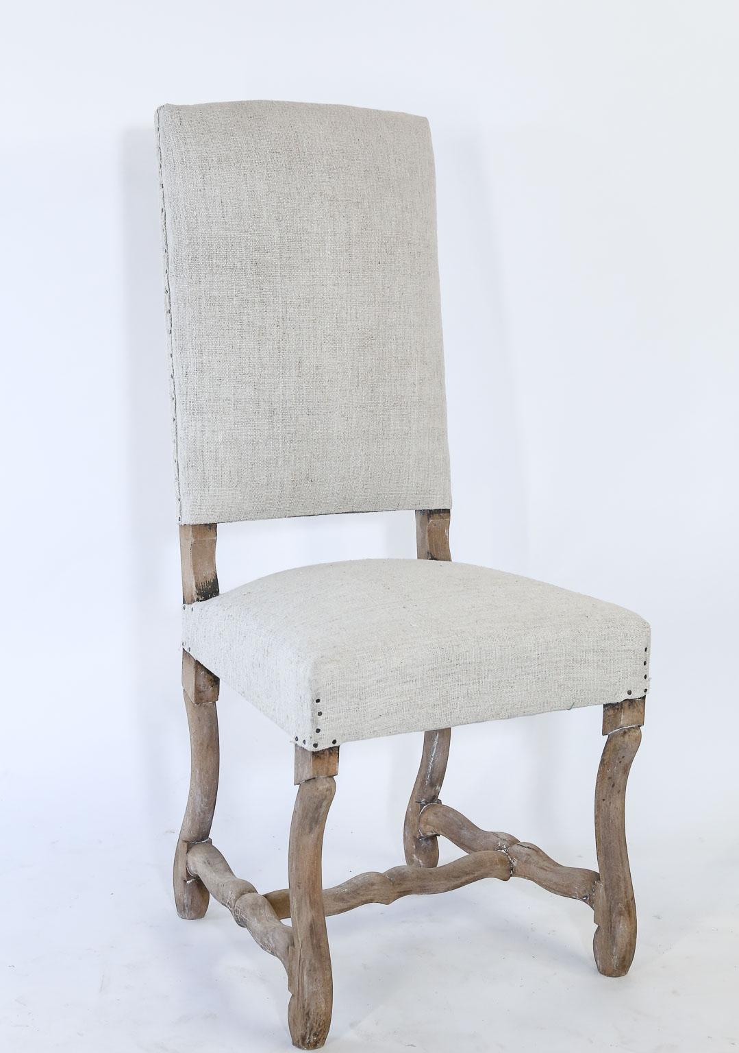 This is a set of six newly upholstered dining side chairs from France. The wood legs have been stripped and lightly white washed for a neutral look. The fabric on the chairs is vintage French linen and is enhanced with small tacks. Perfect for a