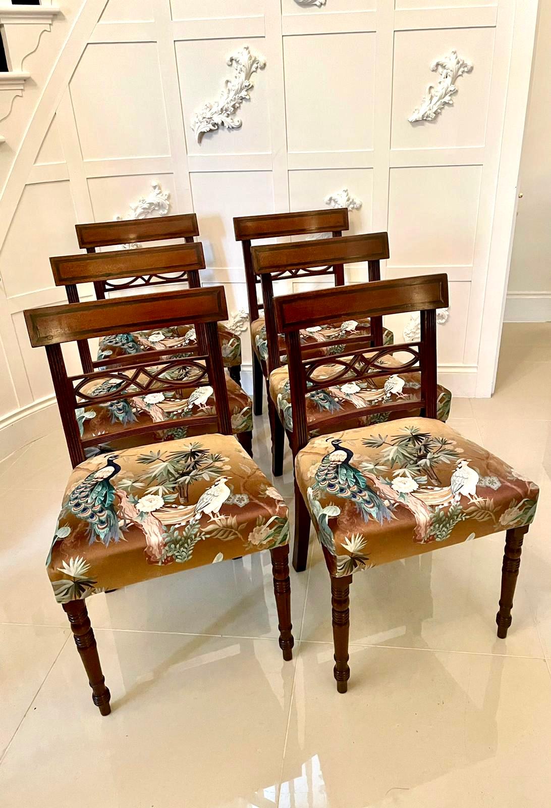 Fine set of six antique Regency mahogany dining chairs having fine inlaid and reeded top rails and expertly carved centre splats. They stand on elegant turned tapering legs to the front and outswept back legs. They have been newly reupholstered in a