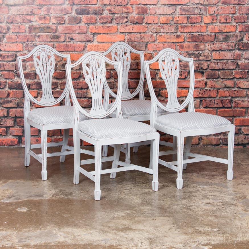 Lovely set of six matching dining chairs from Sweden, four side chairs and two arm chairs - painted an off white that accentuates the classic lines of the Gustavian style. The new paint has been lightly distressed exposing the natural pine and