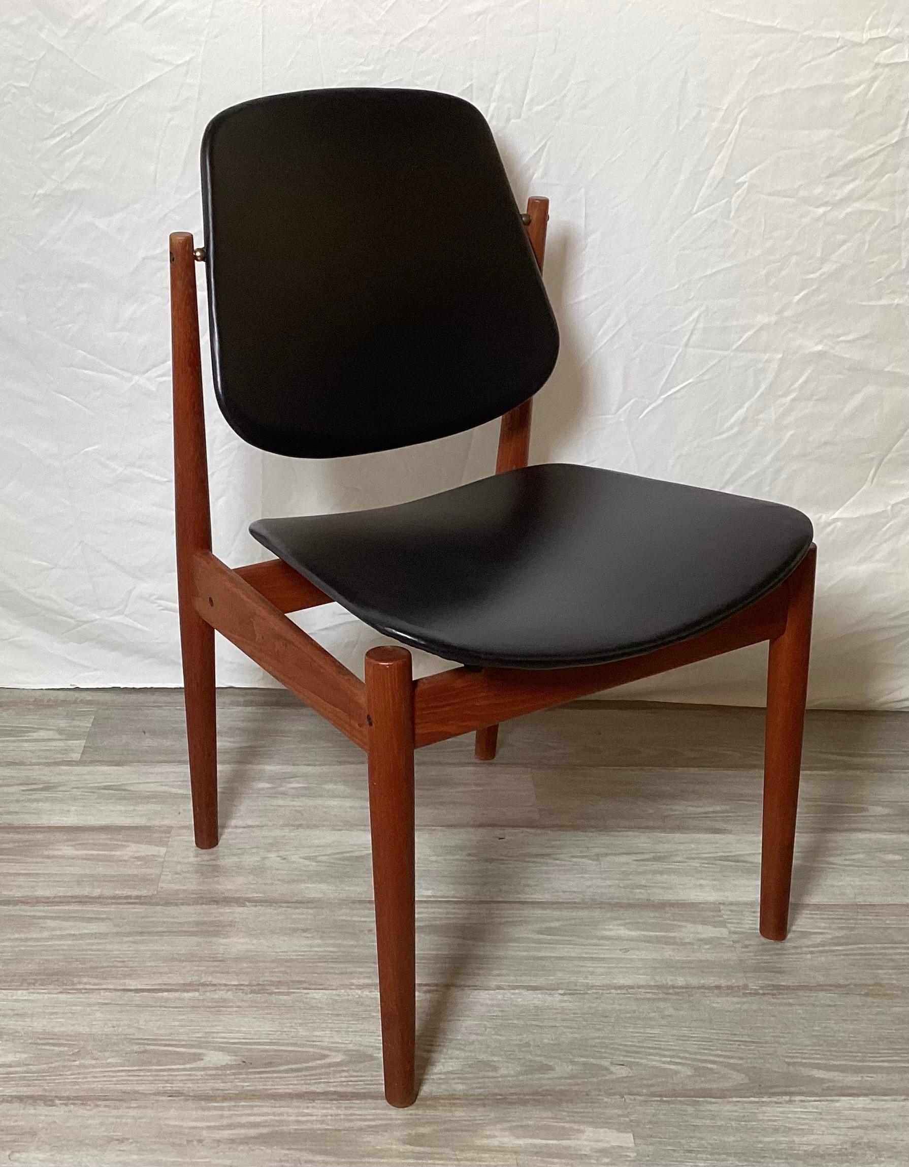 Set of six Dining room chairs by Arne Vodder Teak chairs - 2 arm and 4 side.  Made of Teak wood and original black leatherette material.  Slightly curved for comfort and a sleek profile.  Backrest has a hinged design for extra comfort.