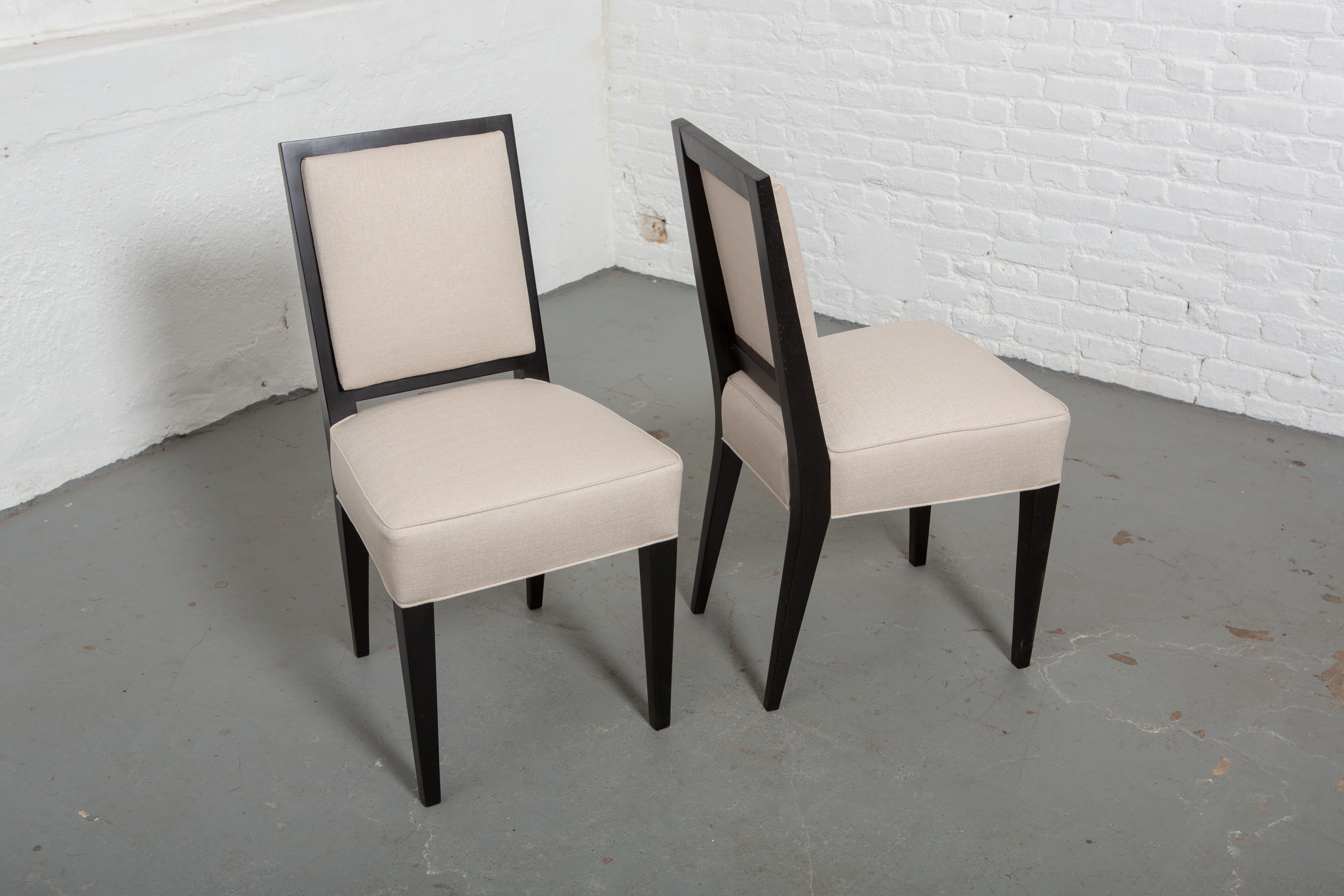 Satz von 6 neu gepolsterten und restaurierten französischen Stühlen im Art Deco-Stil aus Ebenholz mit cremefarbener Polsterung. Gerade Rückenlehne und leicht konisch zulaufende skulpturale Beine. 
Maßnahmen: 15.5