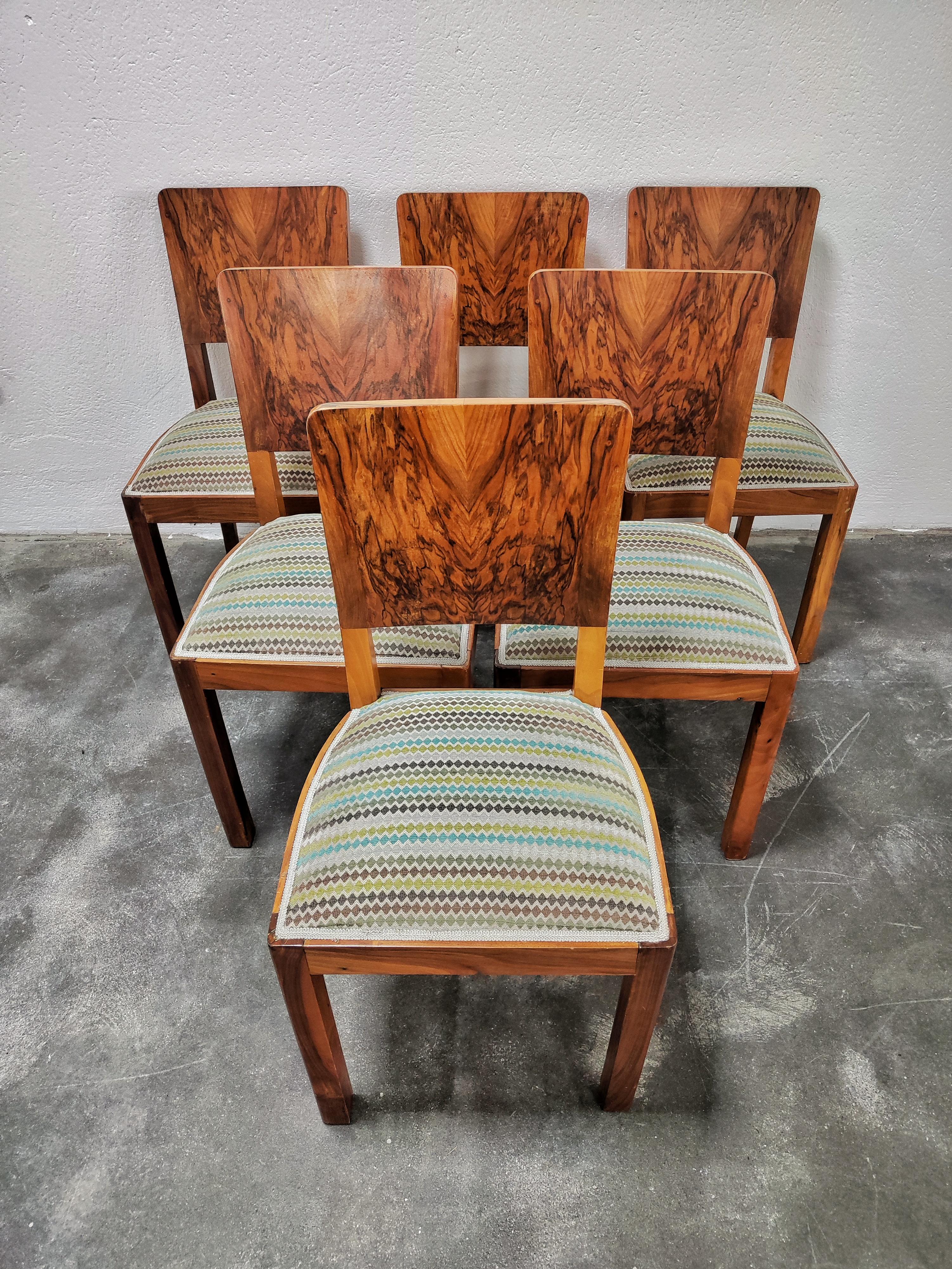 In this listing you will find a set of gorgeous Art Deco dining chairs. They feature the frames done in walnut, while the backrests have been veneered in walnut roots veneer, which is famous for its lavish and dramatic patterns. The chairs have been