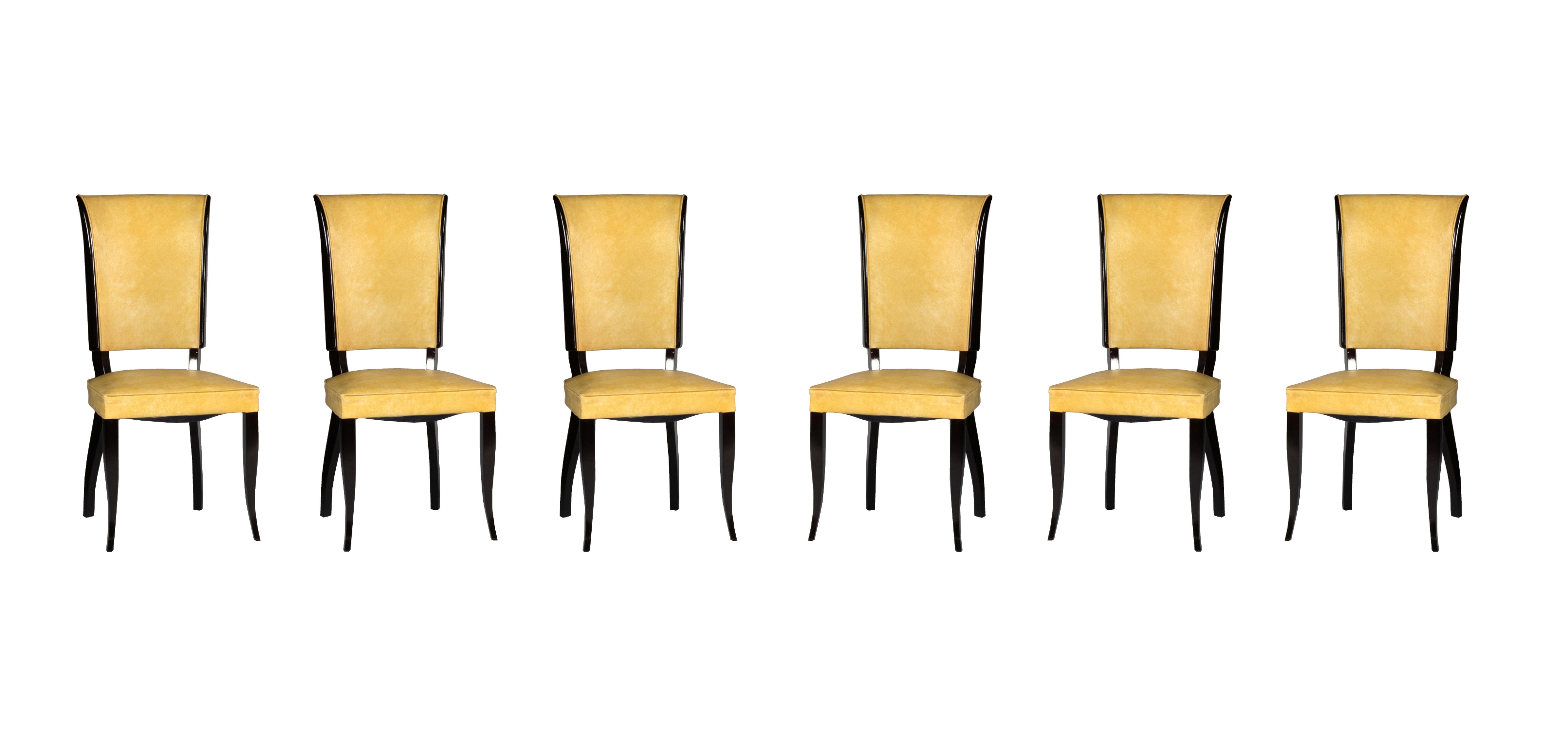 This set of six Art Deco dining chairs features a design inspired by Jules Leleu. 
The chairs have a lacquered doucine base and are upholstered in yellow vinyl. 

Take into account that the colors on the items may vary depending on the type of