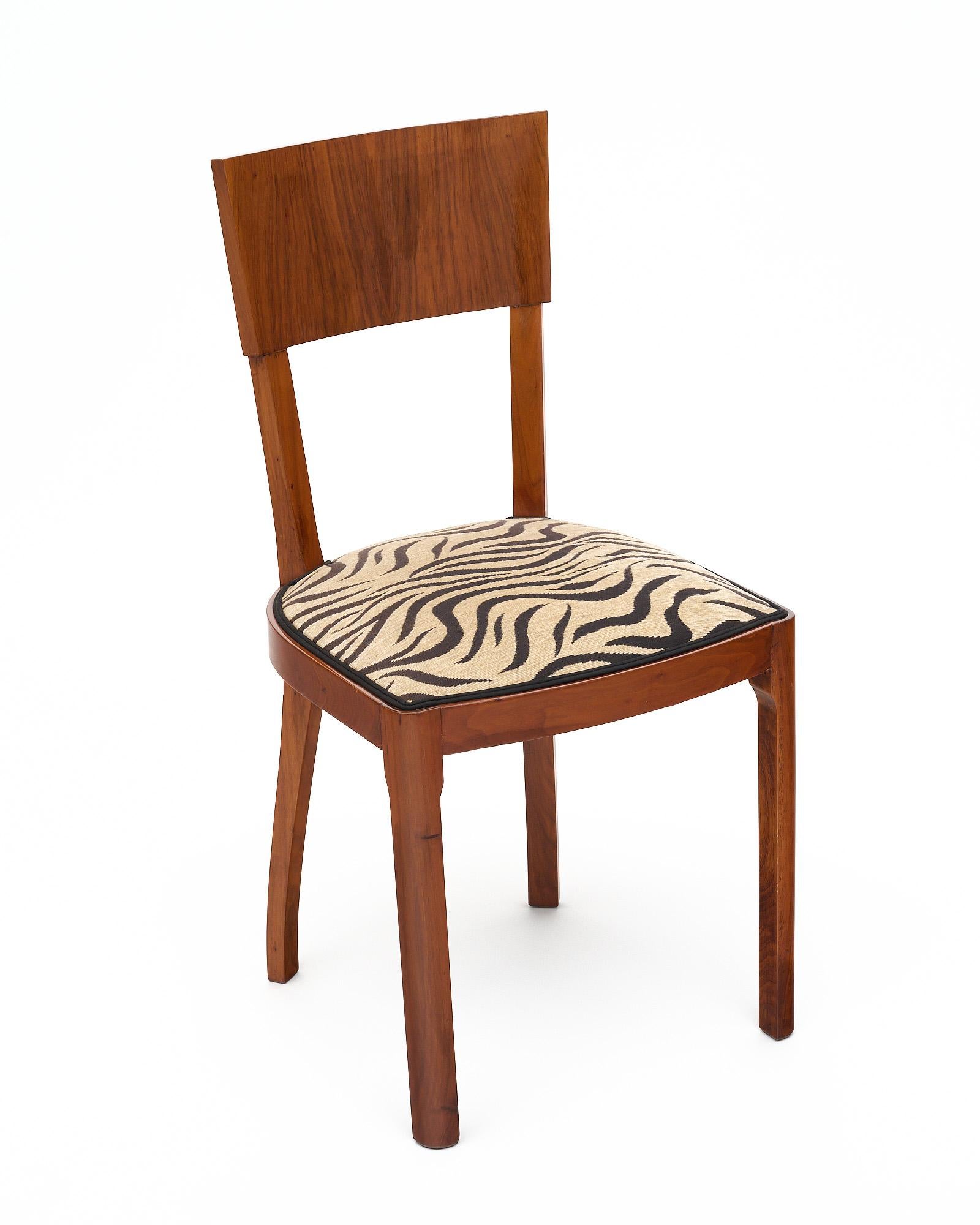 Set of six dining chairs from Austria; of solid walnut and figured walnut veneer. The chairs design features both the modern lines of Art Deco and the feel of Biedermeier  neoclassical designs. They are upholstered in the original zebra striped