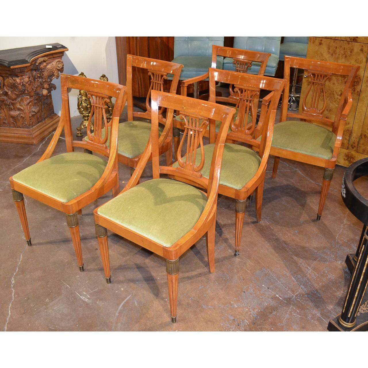 Fabulous set of six Austrian Biedermeier carved maple dining chairs with a beautifully aged patina and comprising two armchairs and four side chairs. Sleek contoured backs with lyre designed splats. The front legs fluted and tapered with brass