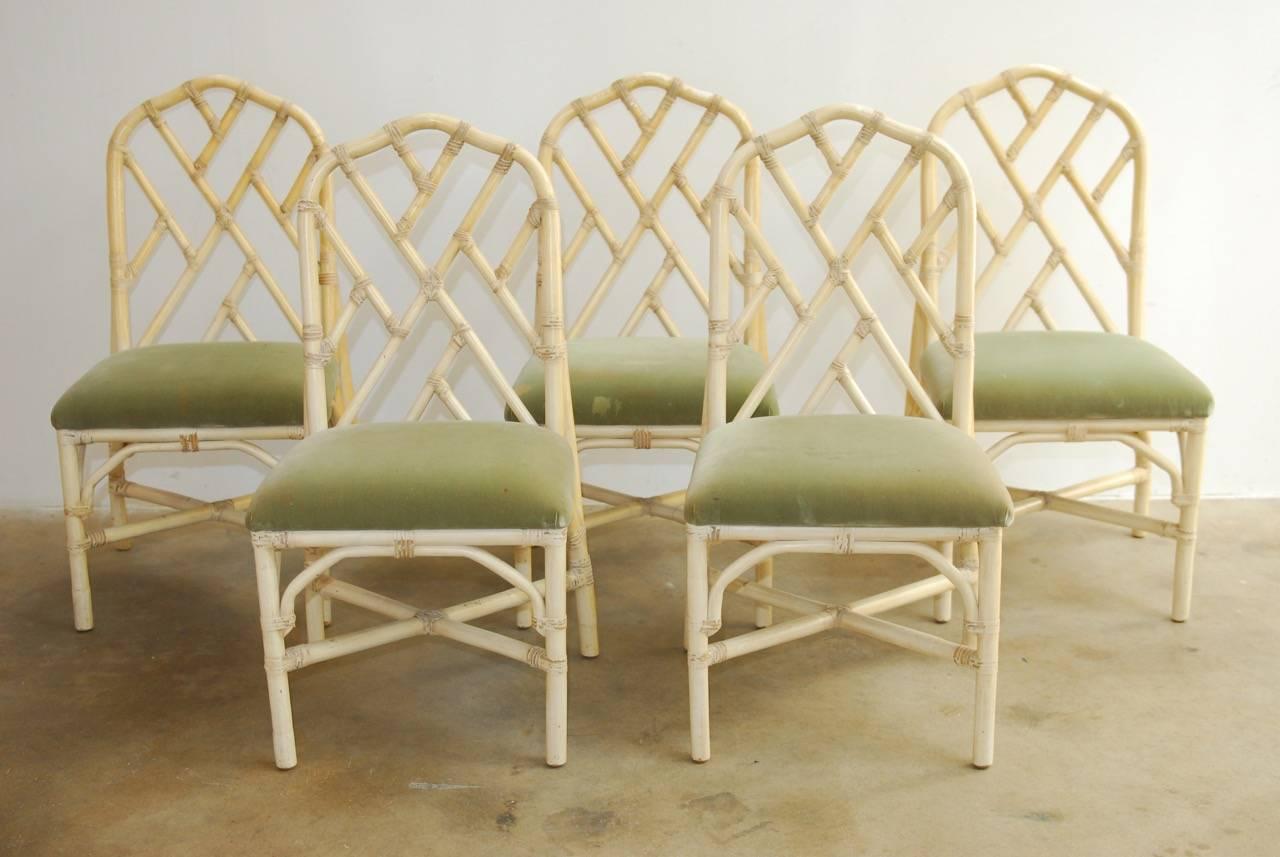 Fabulous set of six bamboo rattan dining chairs made by Brown Jordan in the Chinese Chippendale taste. Featuring a Hollywood Regency style cream lacquer finish with an open fretwork design geometric back. Set consists of five side chairs and one