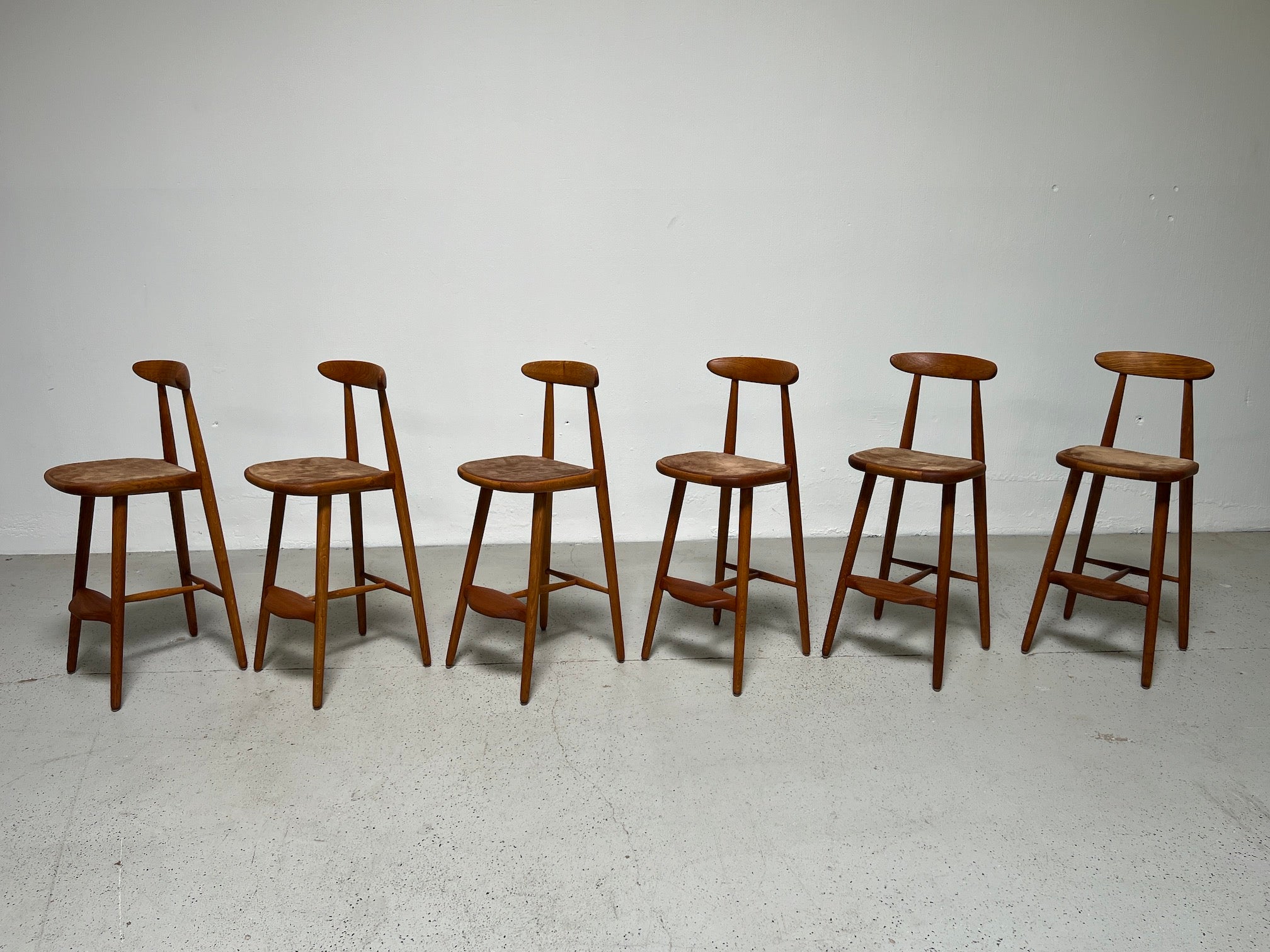 A rare set of six teak and oak barstools with suede seats. Designed by Vilhelm Wohlert for Stolefabriken Odense Denmark.