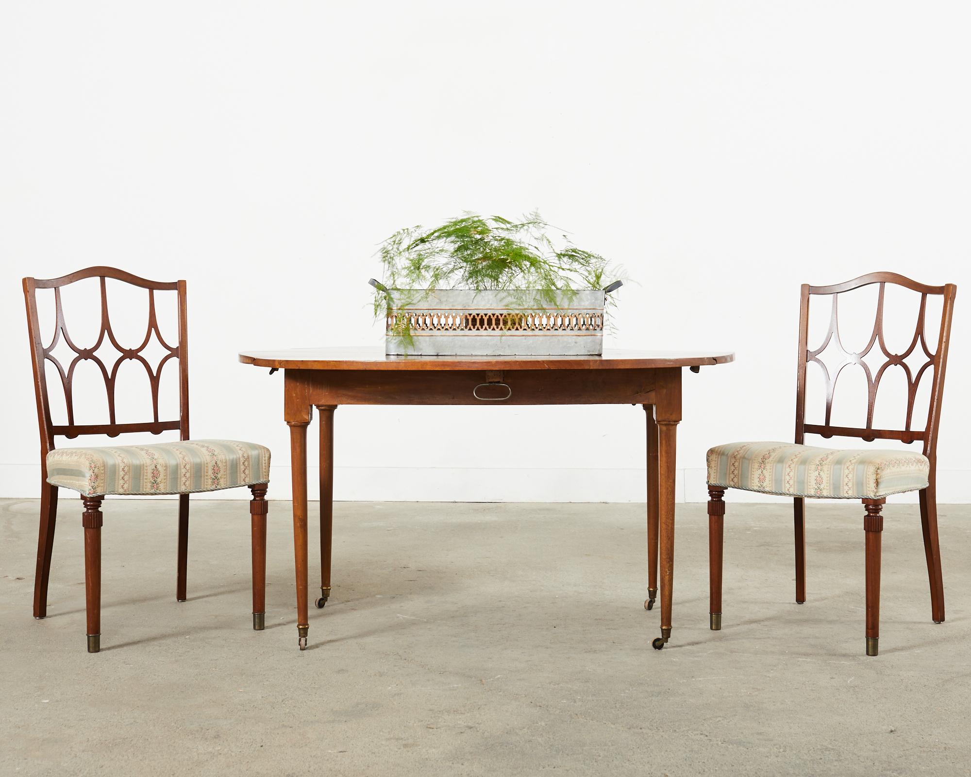 Charming set of six Italian mid-century modern dining chairs featuring distinctive pierced slat backs in the style and manner of Billy Haines. The chairs have a graceful curved hump back and turned legs in the front ending with brass sabots. The