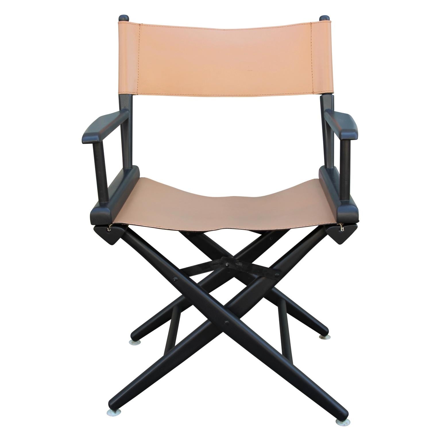 Stylish group of six casual folding chairs by the Telescope Folding Furniture Company. 
The wooden frame of each chair is finished in a black patina while the seats are made out of tan leather. Each leather back cover has been refurbished in the