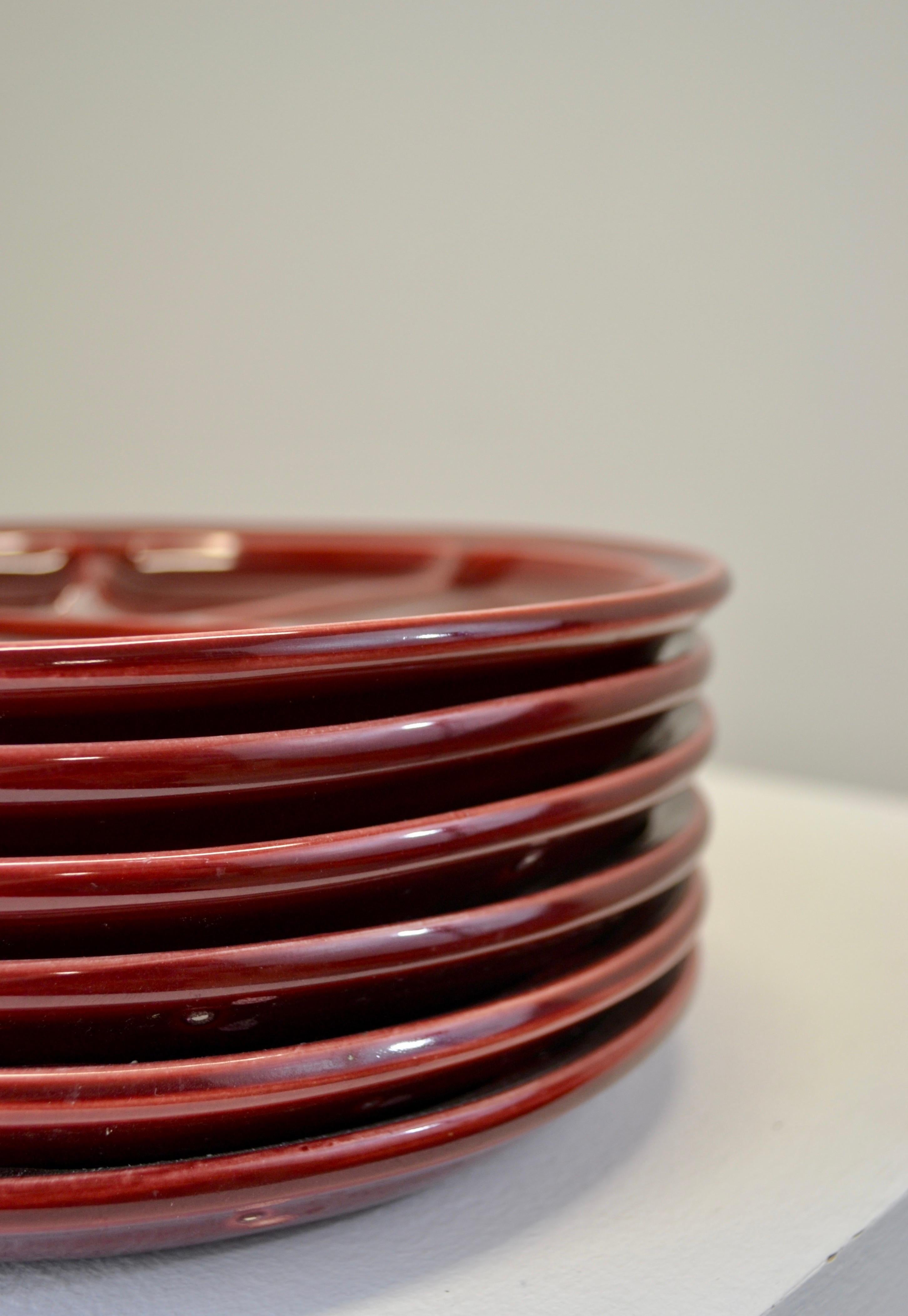 Elegante set di sei piatti da fonduta realizzati dal rinomato produttore francese di ceramiche Gien, risalenti agli anni '60. Questi piatti dai ricchi colori bordeaux mostrano la raffinata abilità artigianale e l'estetica senza tempo per cui Gien è