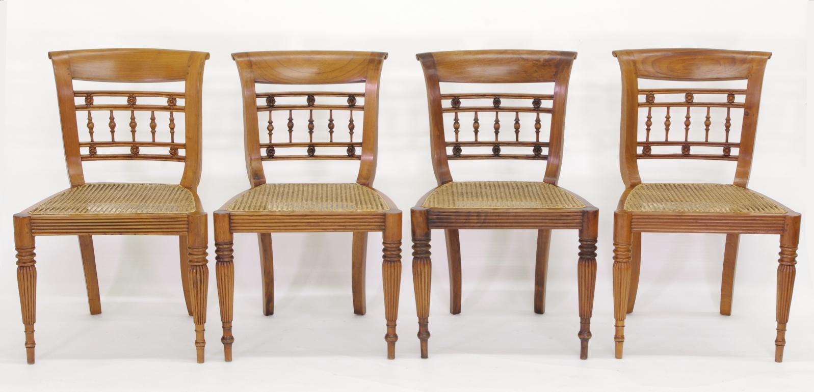 Set of six British colonial dining chairs, comprising two armchairs and four sides, each with a tablet crest over the rosette and spindle back; the caned seat framed by reeded rails and raised on turned and reeded legs.

The distinctive 'loop