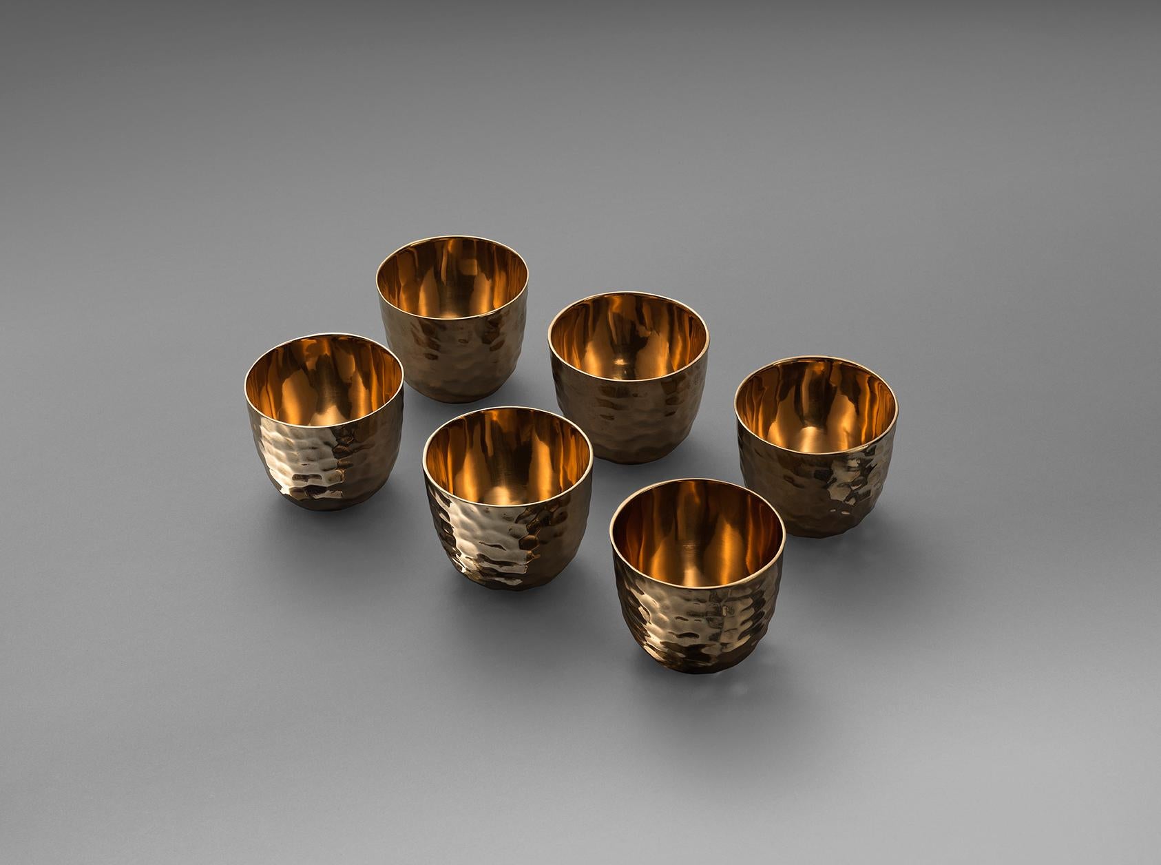 Bronze is a material as old as civilization itself and yet it has been overlooked in favour of gold and silver, porcelain and glass for tableware for many generations. 

This set of bronze cups has been cast and is highly polished. The hand-wrought