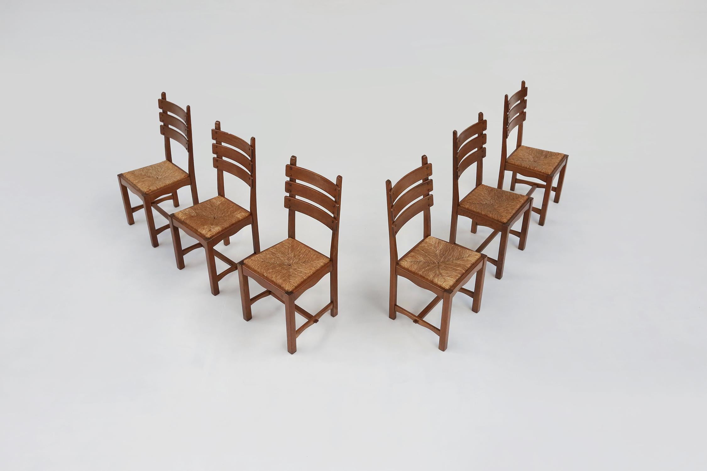 Impressionnant ensemble de chaises de salle à manger brutalistes belges. Composé d'une base en chêne massif et d'un siège en paille de jonc. Avec de jolis détails dans les joints en bois du dossier.