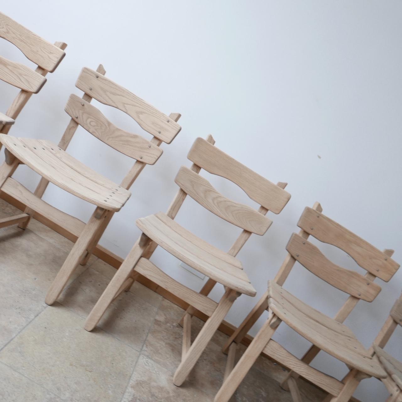 A set of of six stripped oak dining chairs. 

Belgium, c1970s. 

The wood has been sanded which is can be left as is, or our restorer can wax and colour to taste. 

Good condition, sturdy, solid and comfortable. 

Two chairs unusually don't