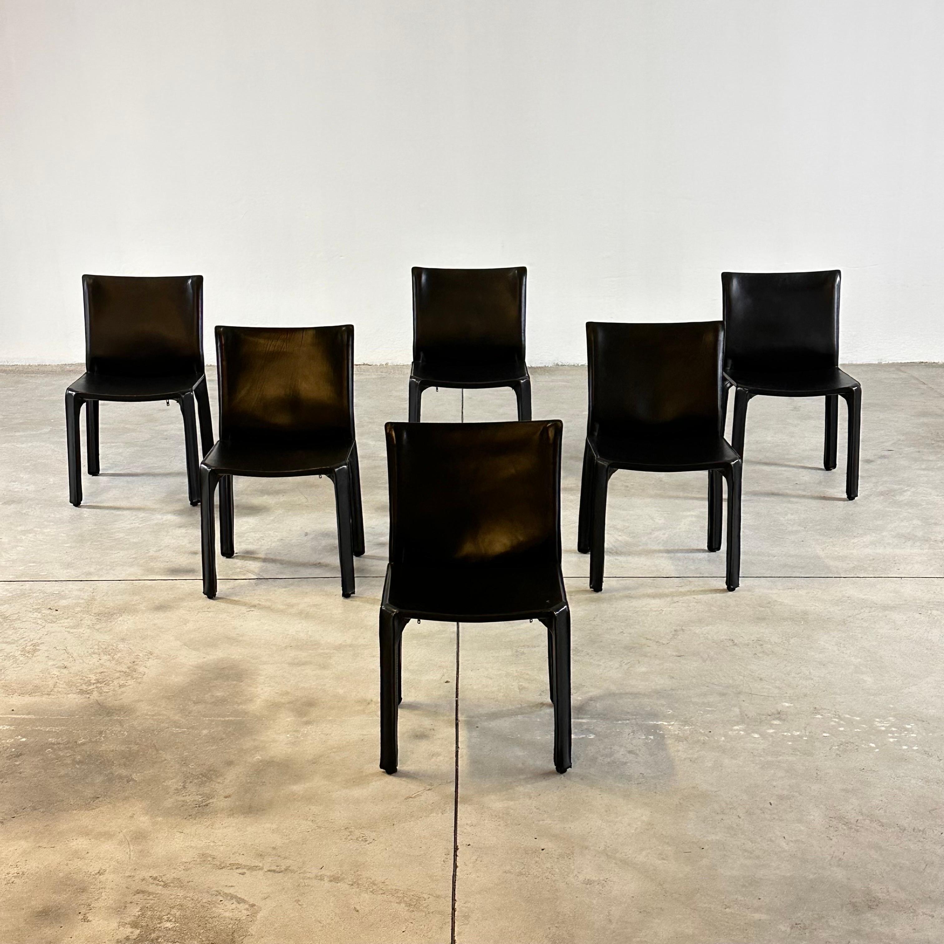 A set of six Italian design icons in black saddle leather.

When first produced in 1977, the CAB was the first chair to feature a free-standing leather structure, inspired by how human skin fits over our skeleton. The leather upholstery is