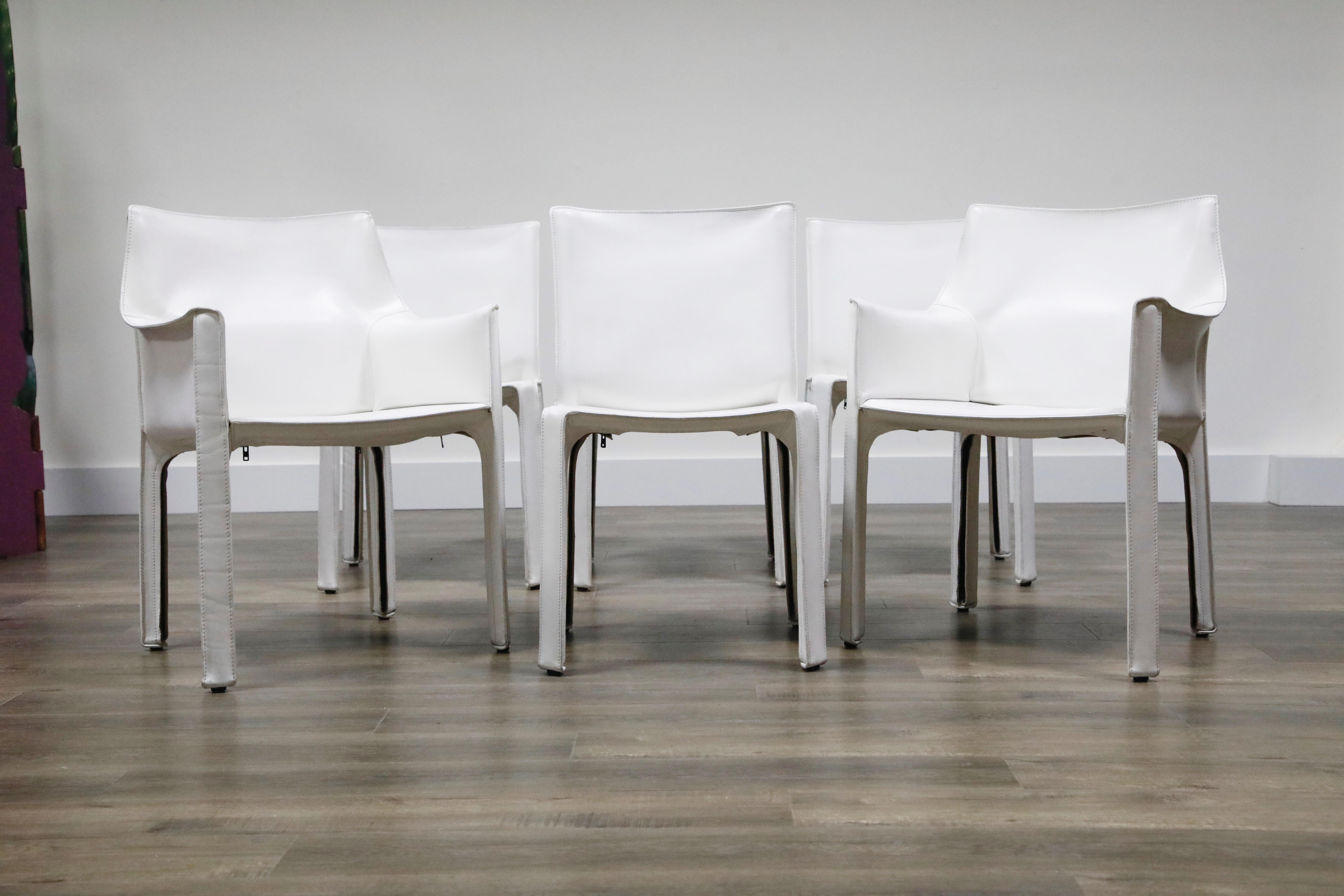 A beautiful set of Mario Bellini cab dining chairs in white leather, comprised of two (2) model #413 armchairs and four (4) model #412 side chairs, signed Cassina underneath each example, designed in the 1970s, these examples produced circa 1990s.