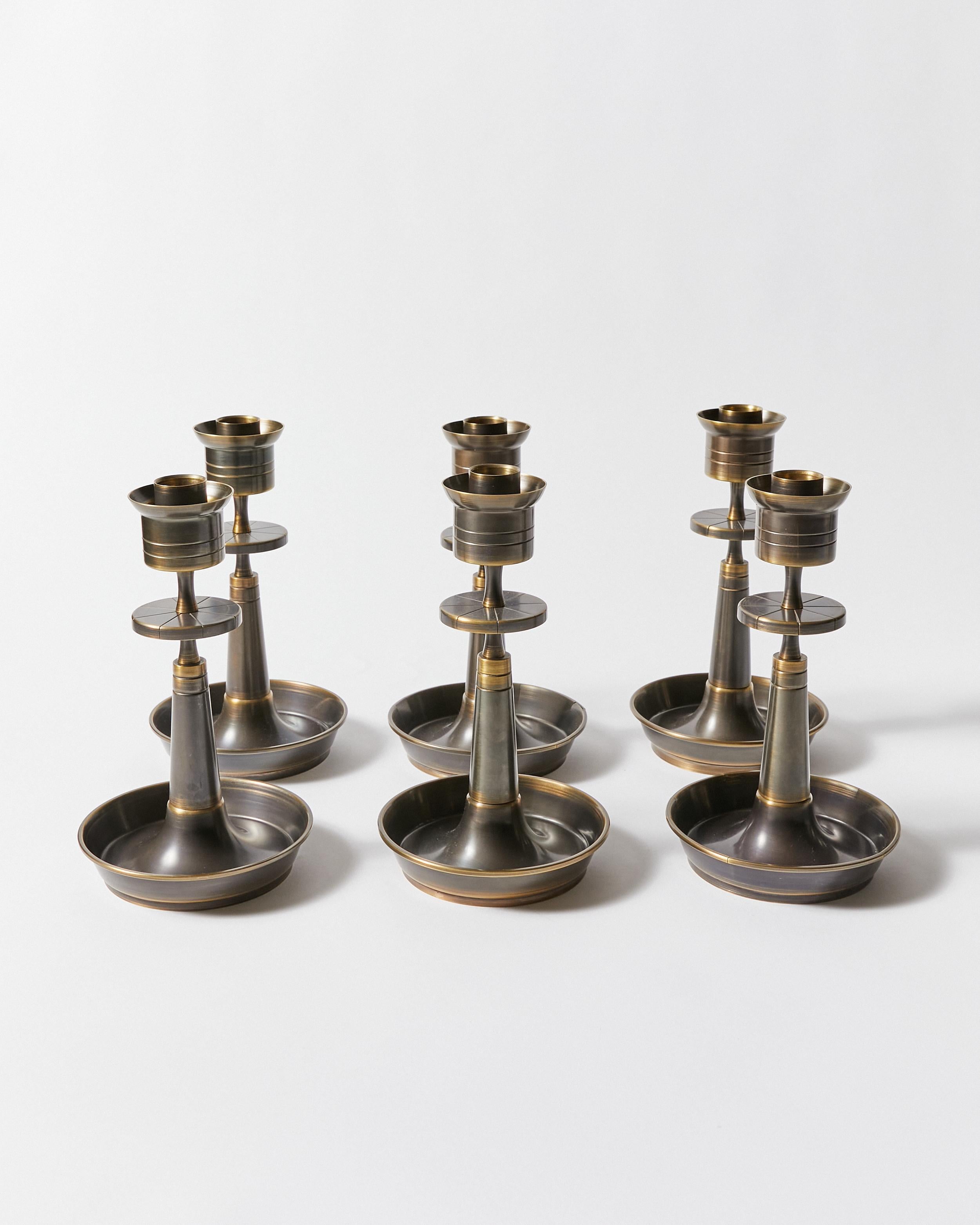 Set of six candle holders with a circular saucer base and a tapering candleholder with engraved plate. All refinished in Antique Bronze.
Designed by Tommi Parzinger for Dorlyn Silversmiths. Stamped on bottom.