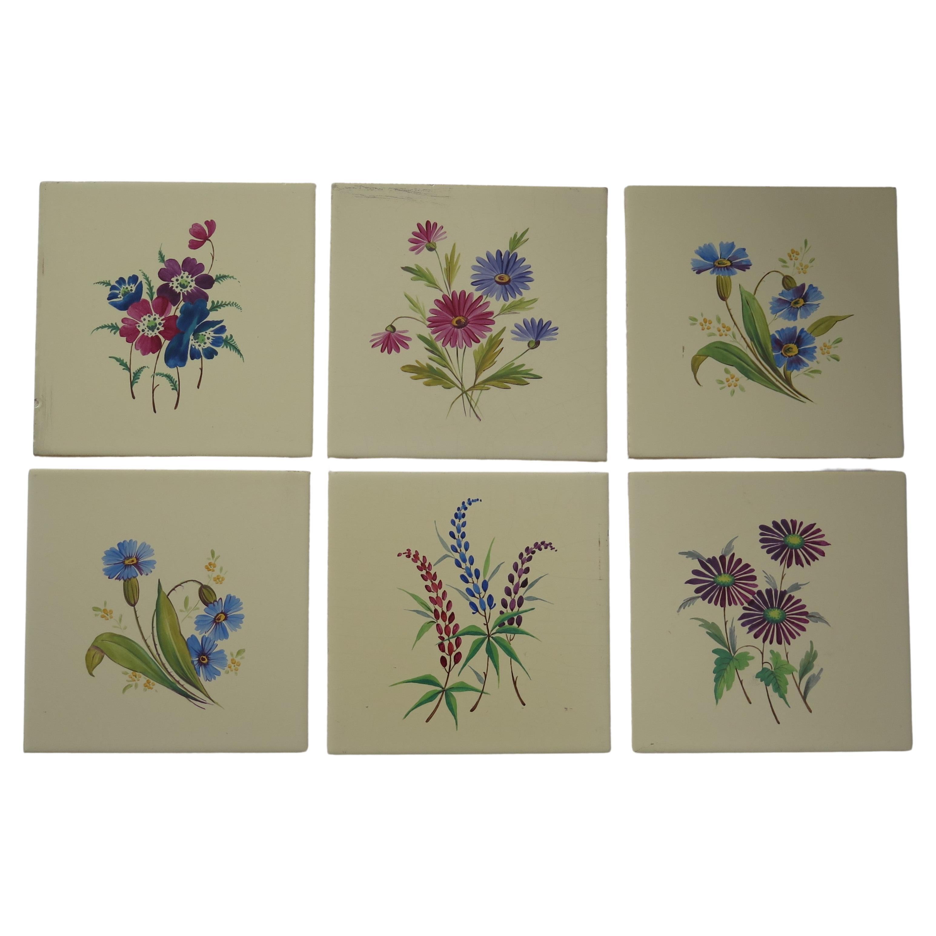 Es handelt sich um einen guten Satz von SECHS glasierten Wandfliesen aus Keramik, die von Hand mit einzelnen Blumen emailliert wurden und aus dem frühen 20. Jahrhundert stammen, etwa aus dem Jahr 1920. 
Die Fliesen wurden von The Campbell Tile Co.