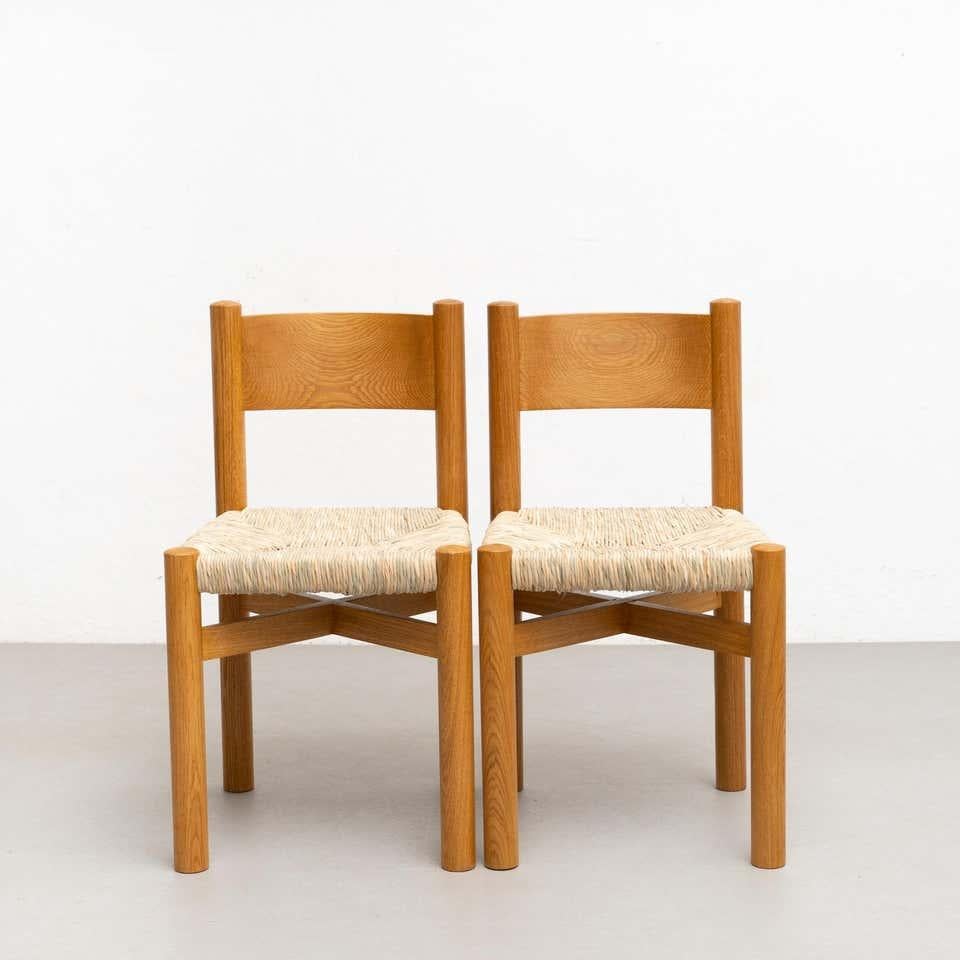 Set of six chairs After Charlotte Perriand, 
By unknown manufacturer, from France, circa 1980.

Materials:
Wood and rattan.

In original condition, with minor wear consistent with age and use, preserving a beautiful patina.

