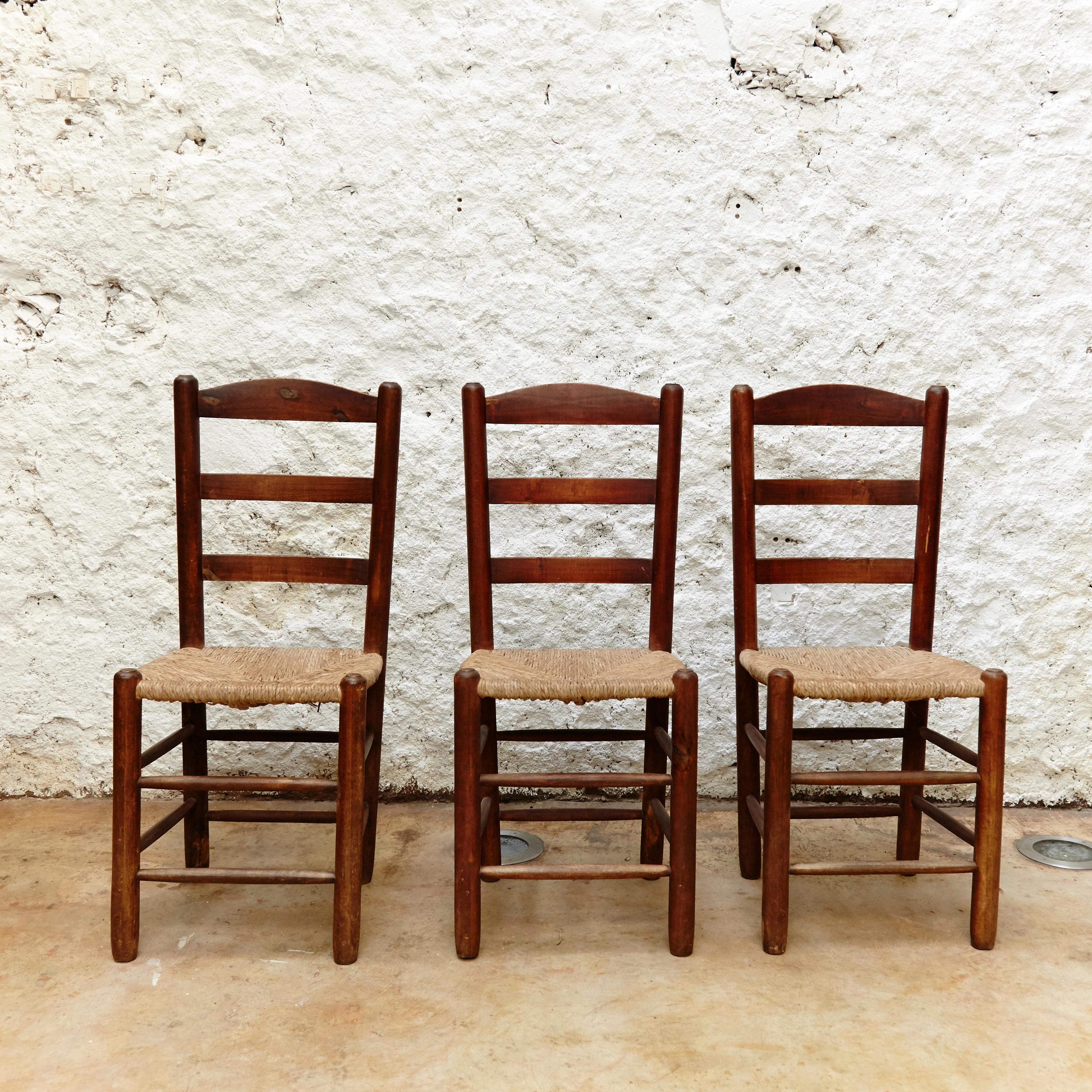 Chairs designed in the style of Charlotte Perriand, made by unknown manufacturer.

Wood and rattan.

In original condition, with minor wear consistent with age and use, preserving a beautiful patina.

They are 3 slight different from the other