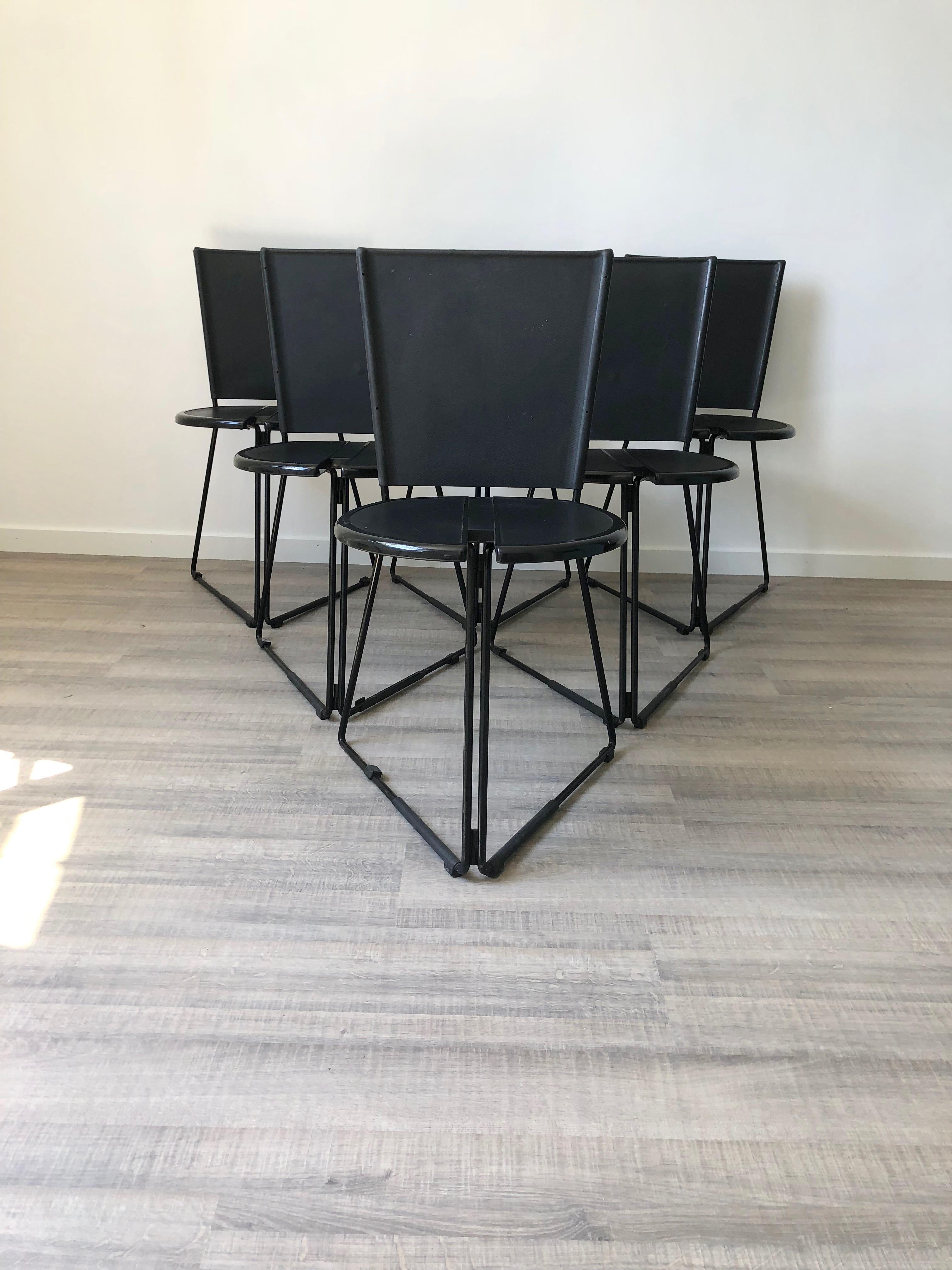 A set of six chairs that feature metal bases with seats in hard plastic and backrests in rubber. They are foldable and stackable.