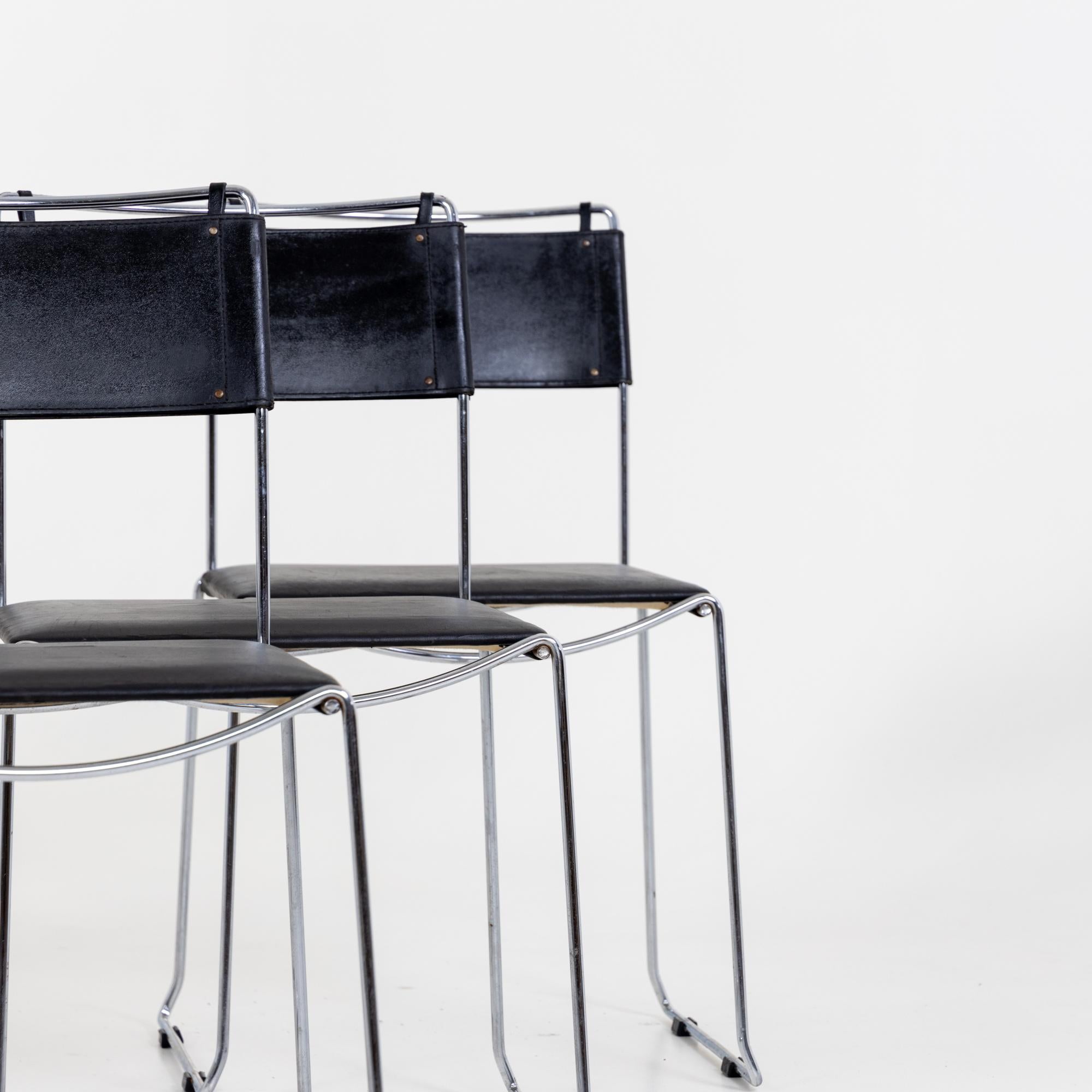 Set of six chairs with chromed metal frames and black seats and backs. The chairs are in good, used condition and covered with a black leather.
