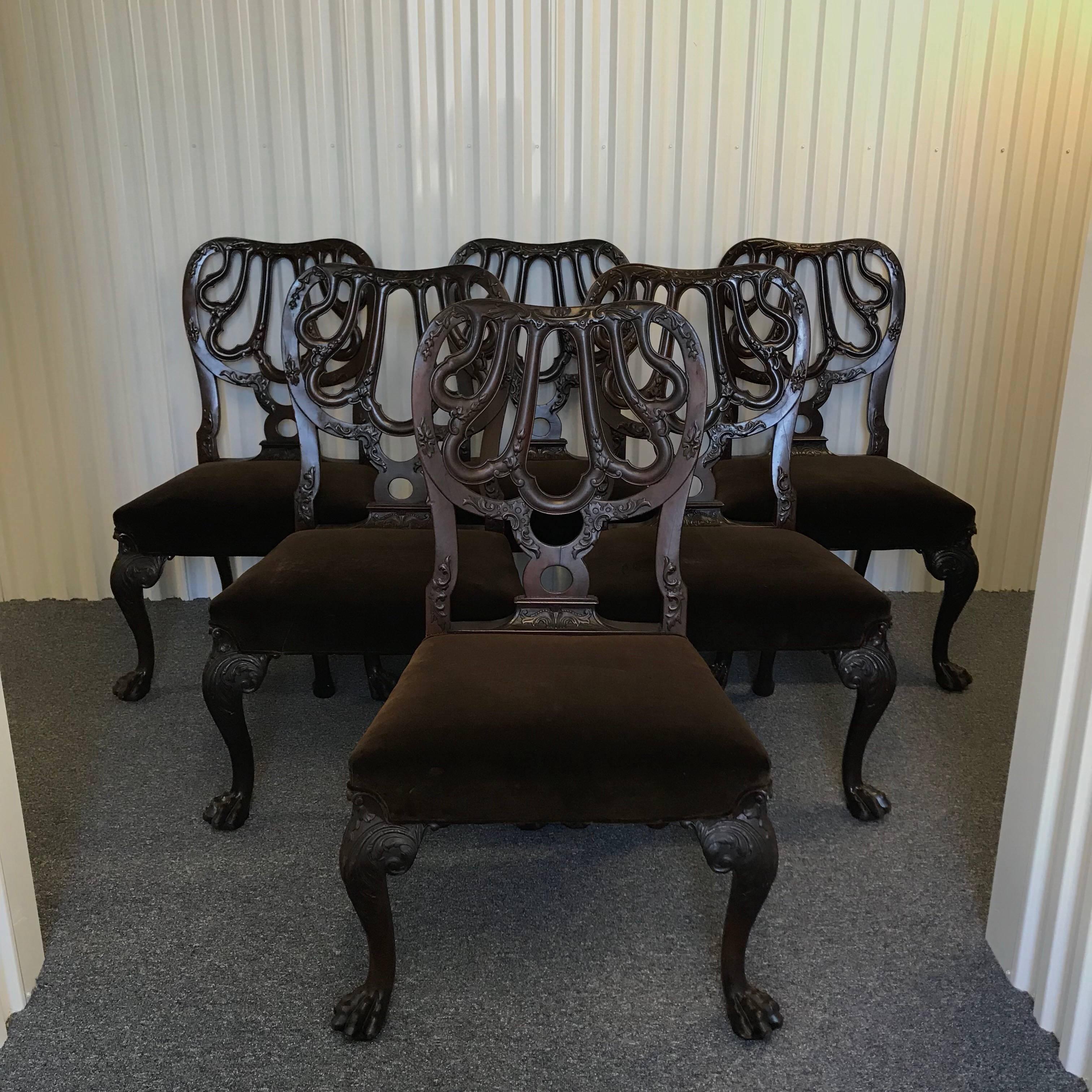 A set of six Chippendale style mahogany dining chairs
20th century.
Each having a shaped crest rail above the openwork splat carved to show foliate scrolls and the tooled stuffover seat, raised on foliate carved cabriole legs ending in paw