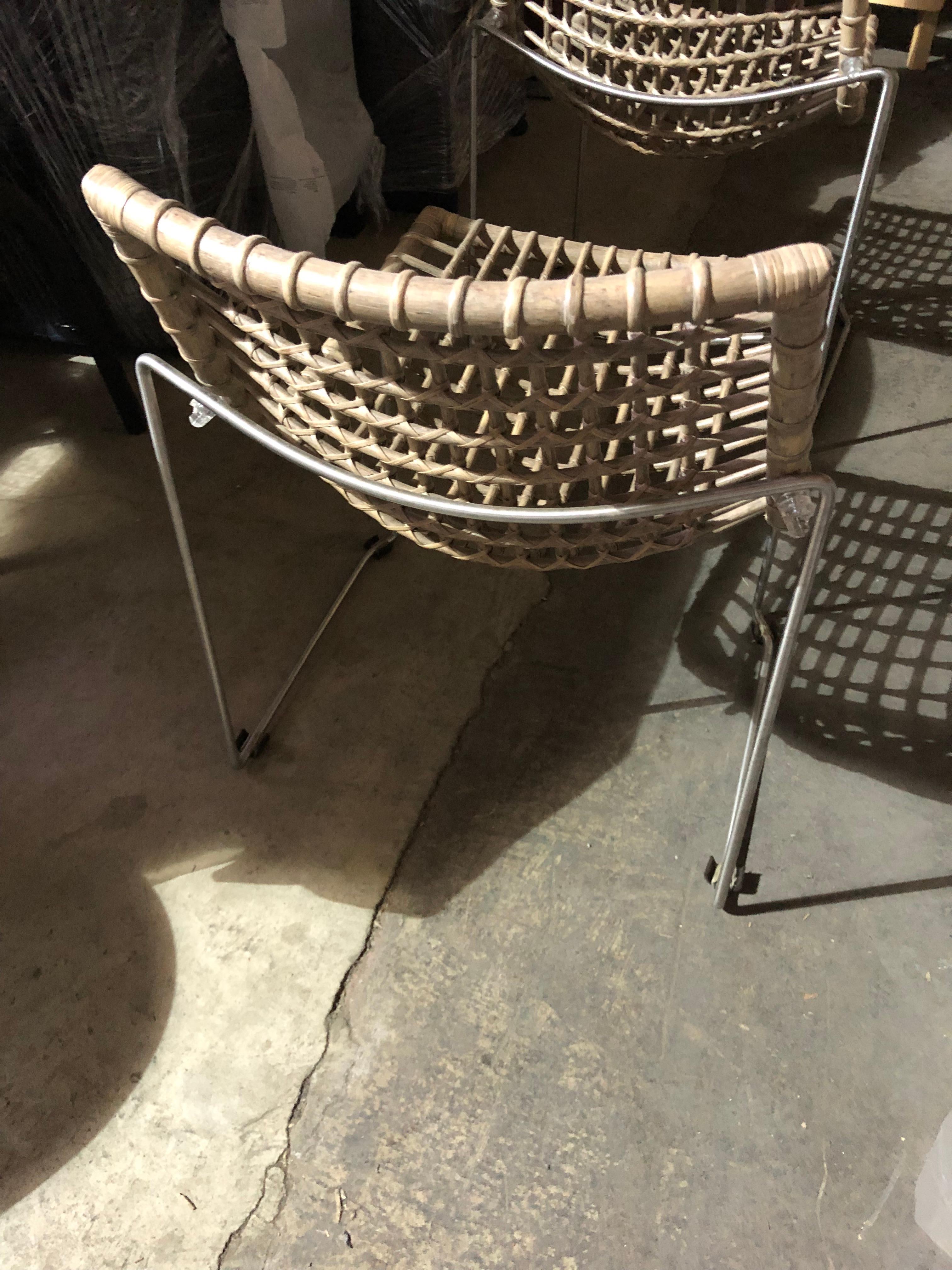 Stackable armchair, net weaving. The shell in rattan with wicker bindings; the frame is in round brushed stainless steel with special hooks in transparent polycarbonate.