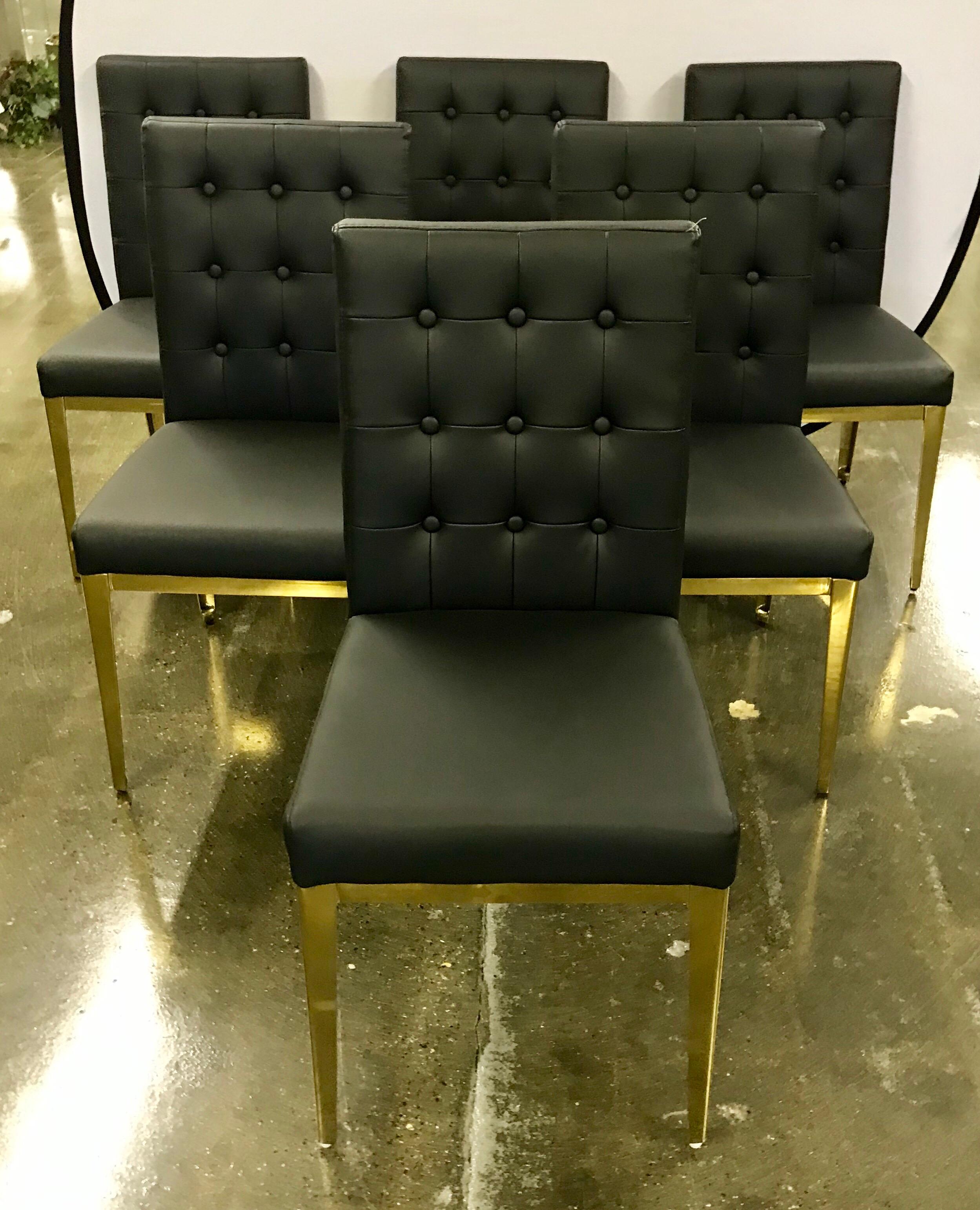 Luxurious set of six black leather and gold brass dining room chairs in mint condition; circa 21st century but with an eye towards the Mid-Century Modern era. This set of chairs will make any dining room pop!
