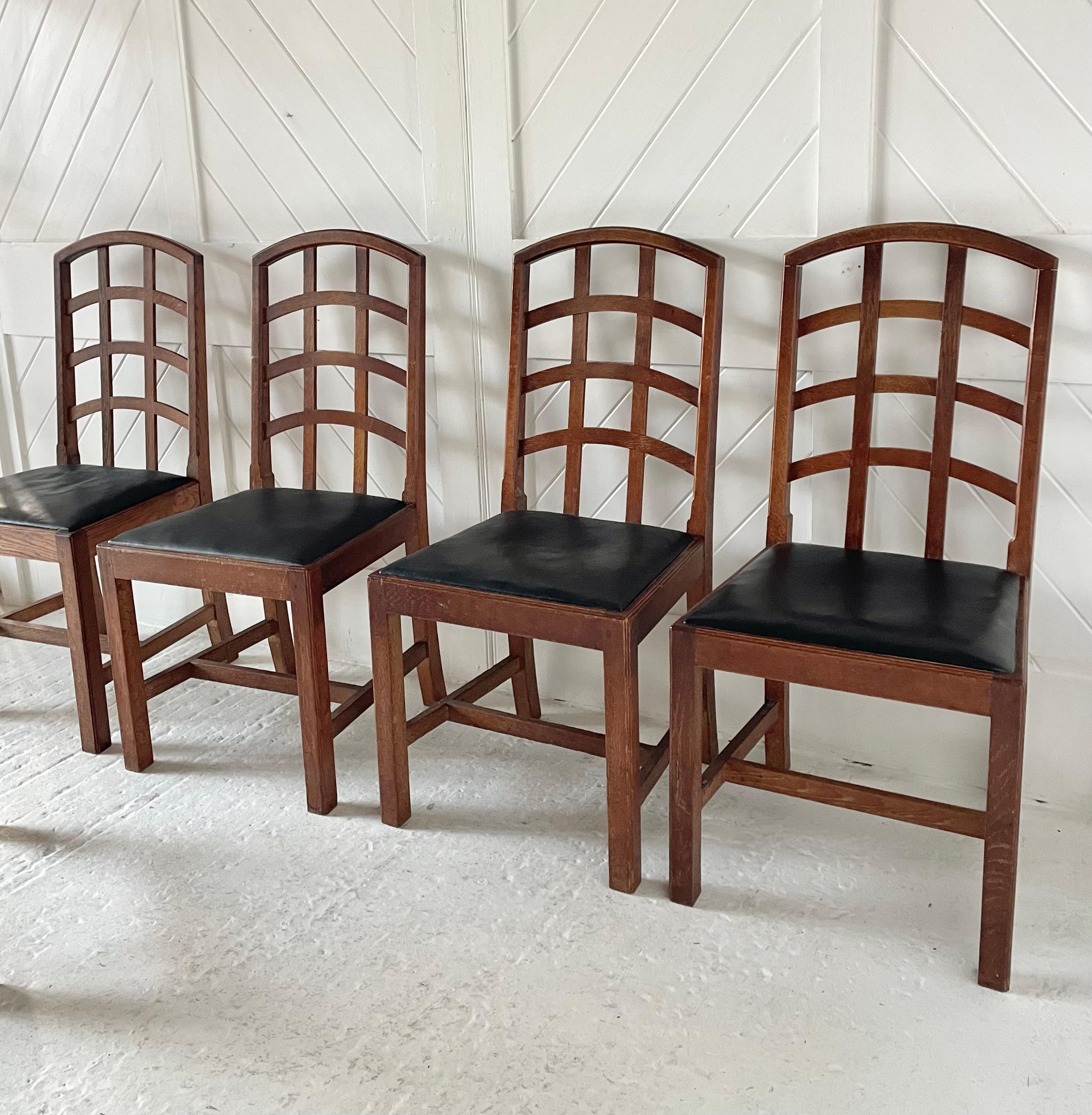 A beautiful set of six Cotswold School dining chairs four single chairs and two carvers. The drop in seats have been recovered in a good quality black leather this is how they arrived with us, but it could be changed very easily. The chairs date