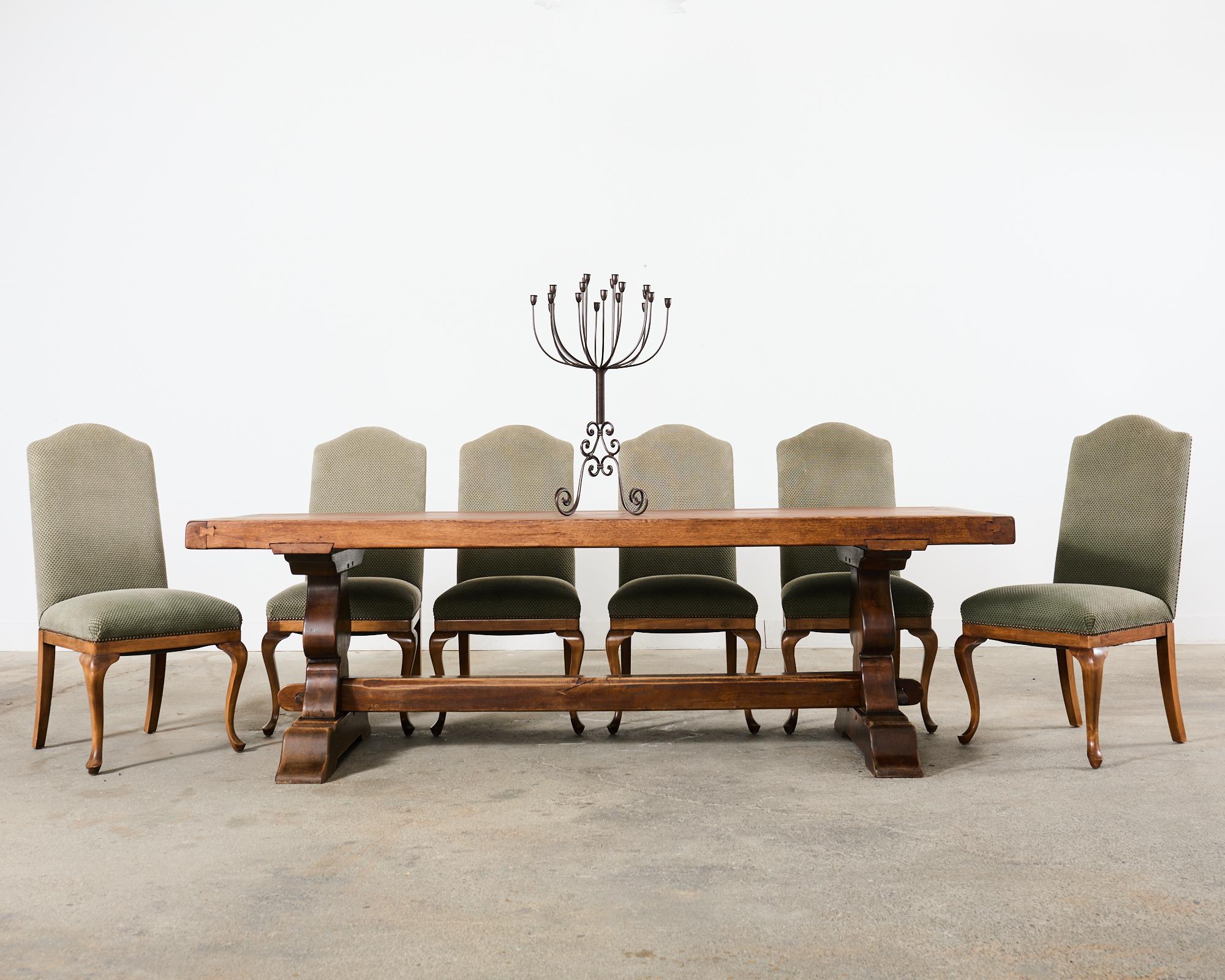 Distinctive set of six walnut dining chairs made in the country English provincial or Georgian style. The chairs feature a generous frame with a humped crest seat upholstered with a textured fabric in a stylish sage green tone. The fabric is