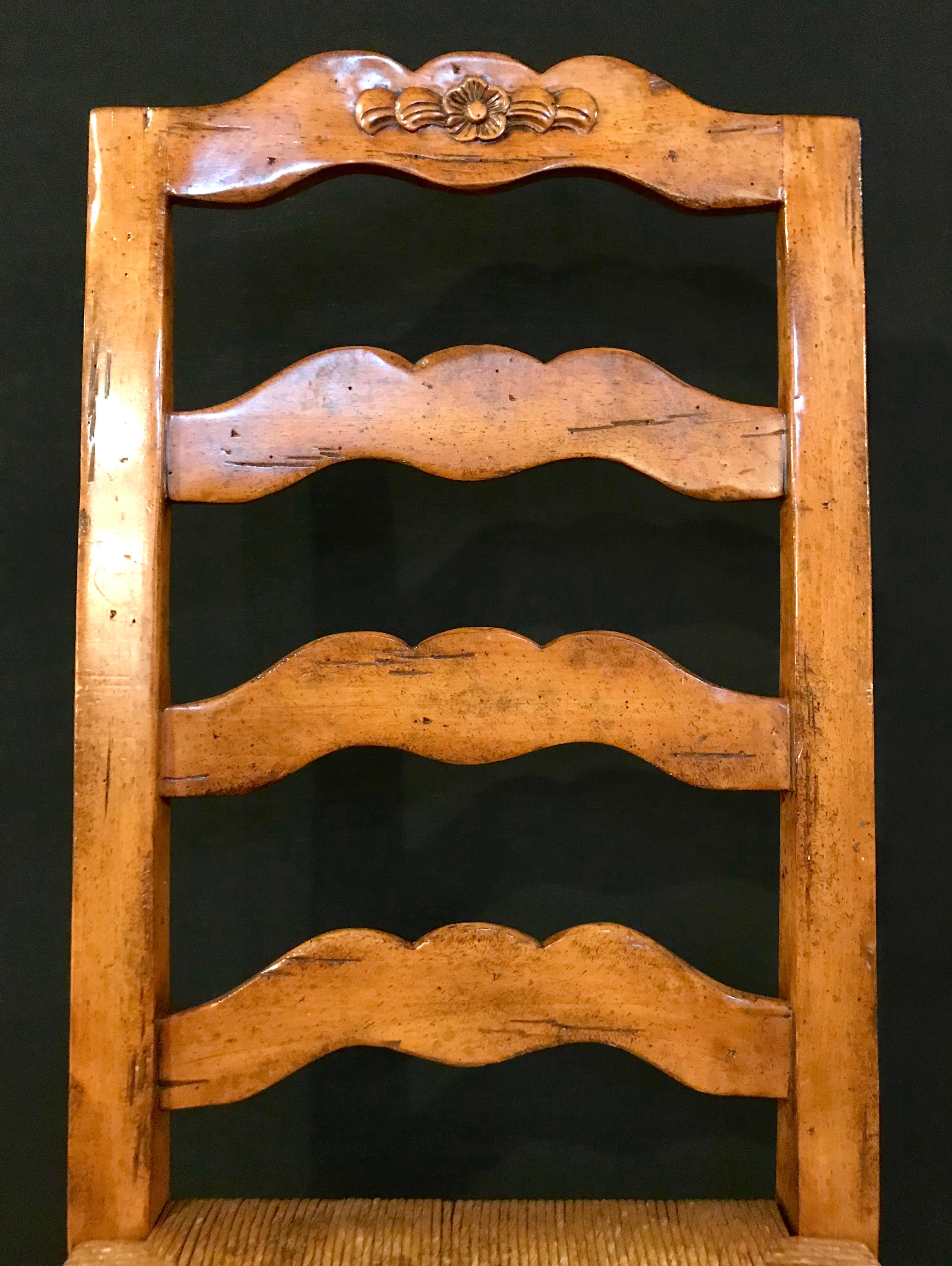 Set of six country French rush seat dining room or breakfast kitchen chairs each in the ladder back fashion with carved rosettes on the top rung. Can purchase four or just a pair. $600 each.