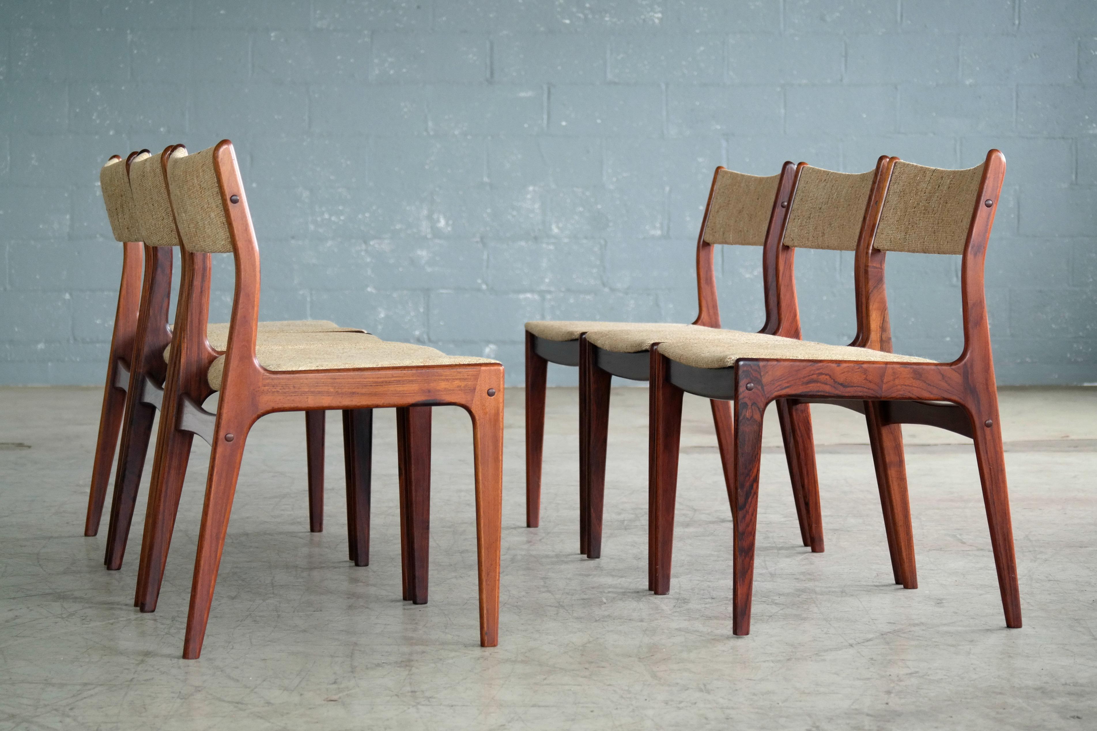 Simple yet refined elegance in these Classic Danish midcentury dining chairs in rosewood and wool made by Uldum (chairs labeled) and quite likely designed by Johannes Andersen. Light comfortable design executed in a beautiful Rio palisander with
