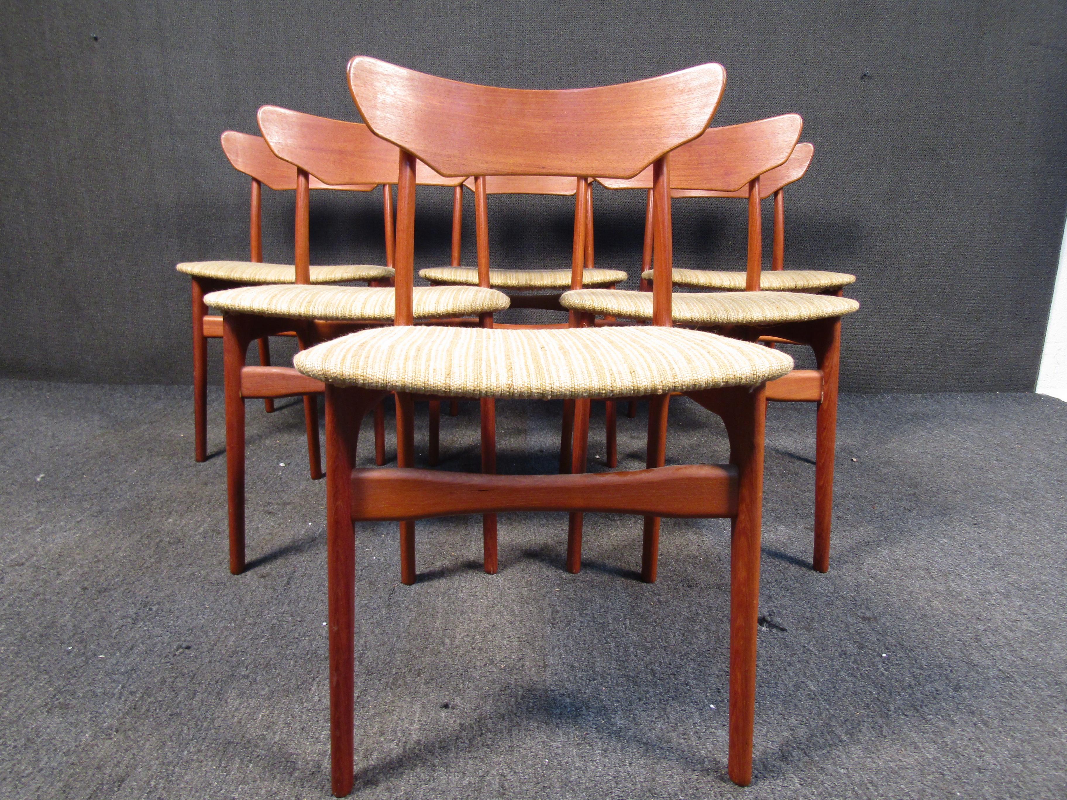 Avec ses cadres élégants en teck sculpté et ses sièges et dossiers rembourrés, cet ensemble de chaises de salle à manger danoises du milieu du siècle constitue un ajout élégant à toute salle à manger. Veuillez confirmer la localisation de l'article