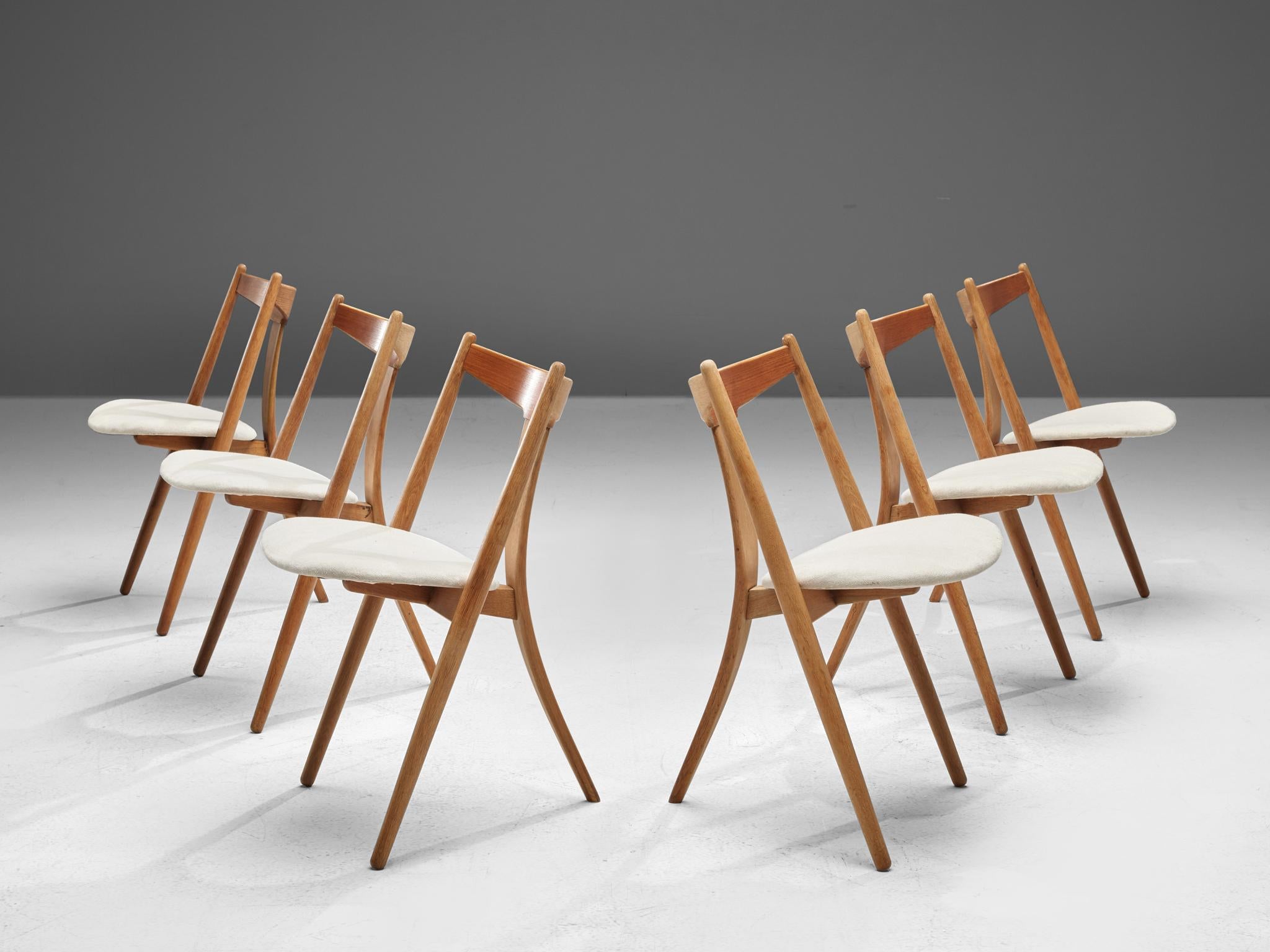 Dining chairs, teak and oak, Denmark, 1950s.

This set of six chairs is made by a cabinetmaker in Denmark. The chairs have a tripod frame made of oak and a backrest executed in teak. The chairs main characteristic is the bent single back leg. The