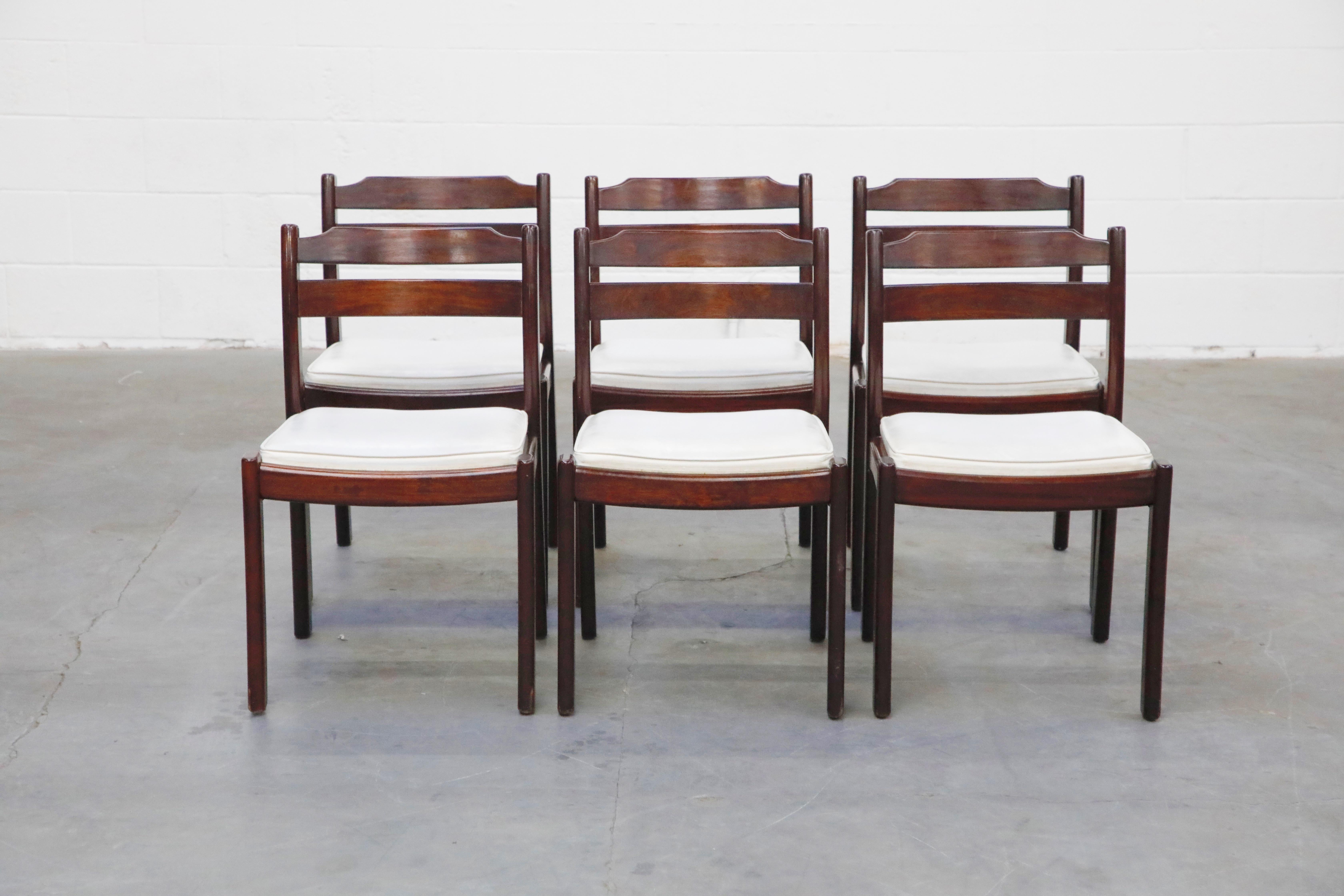 This lovely set of six (6) Danish Modern Rosewood dining chairs are by Dyrlund, circa 1960s, sculpted from Rosewood with white leatherette upholstery, these are a perfect option for interior designers and Mid-Century Modern enthusiasts. Signed